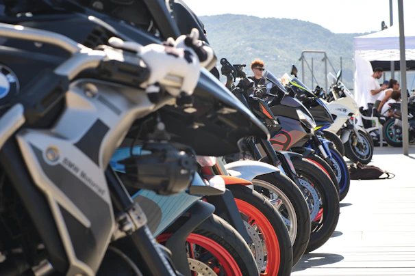 Row of motorcycles parked outdoors on a sunny day.