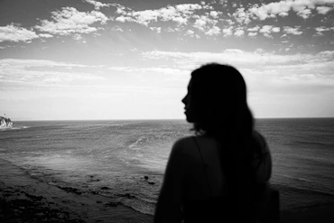 Silhouette of a woman looking at the ocean