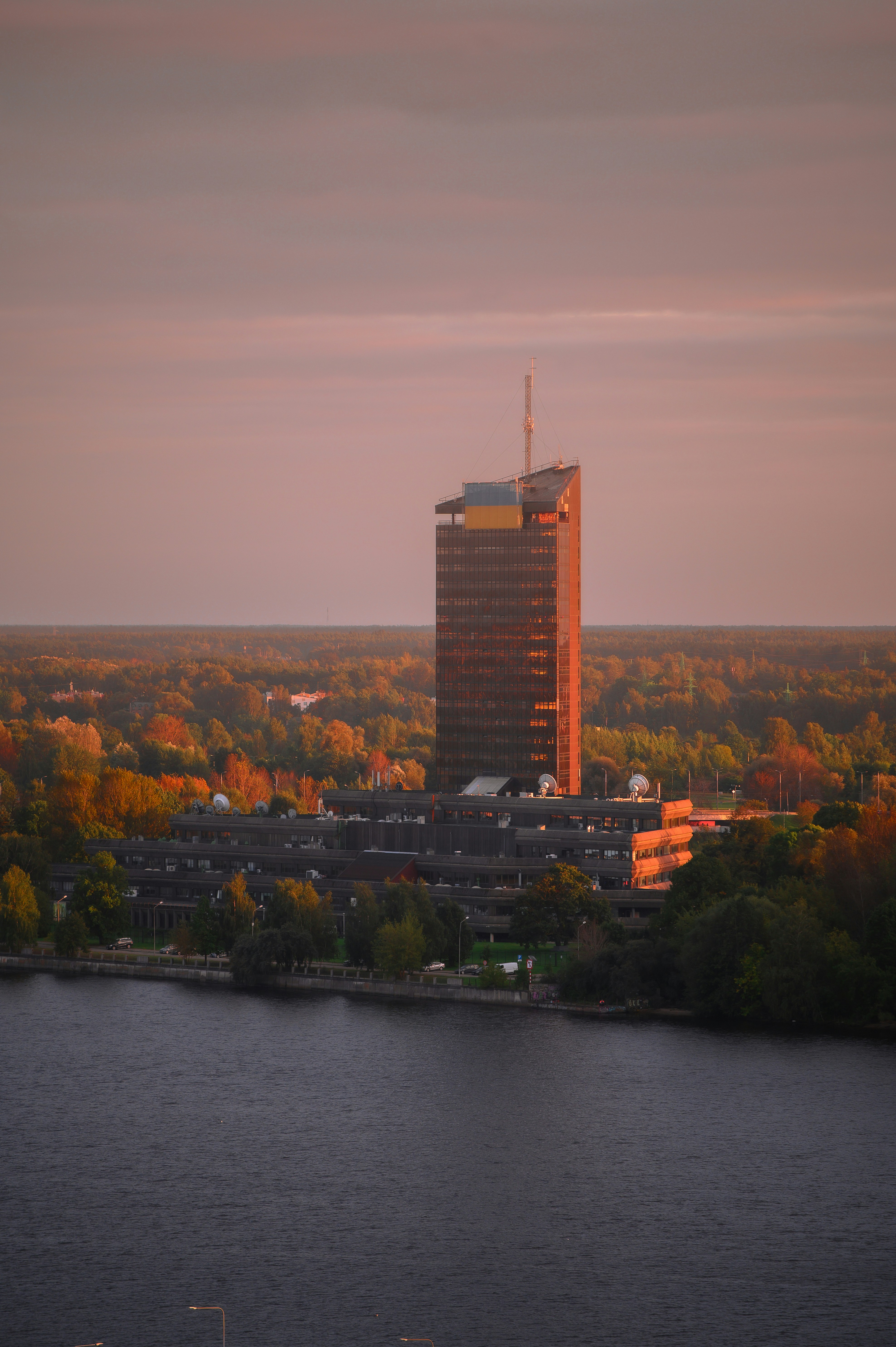 Skyscraper building by the water at sunset