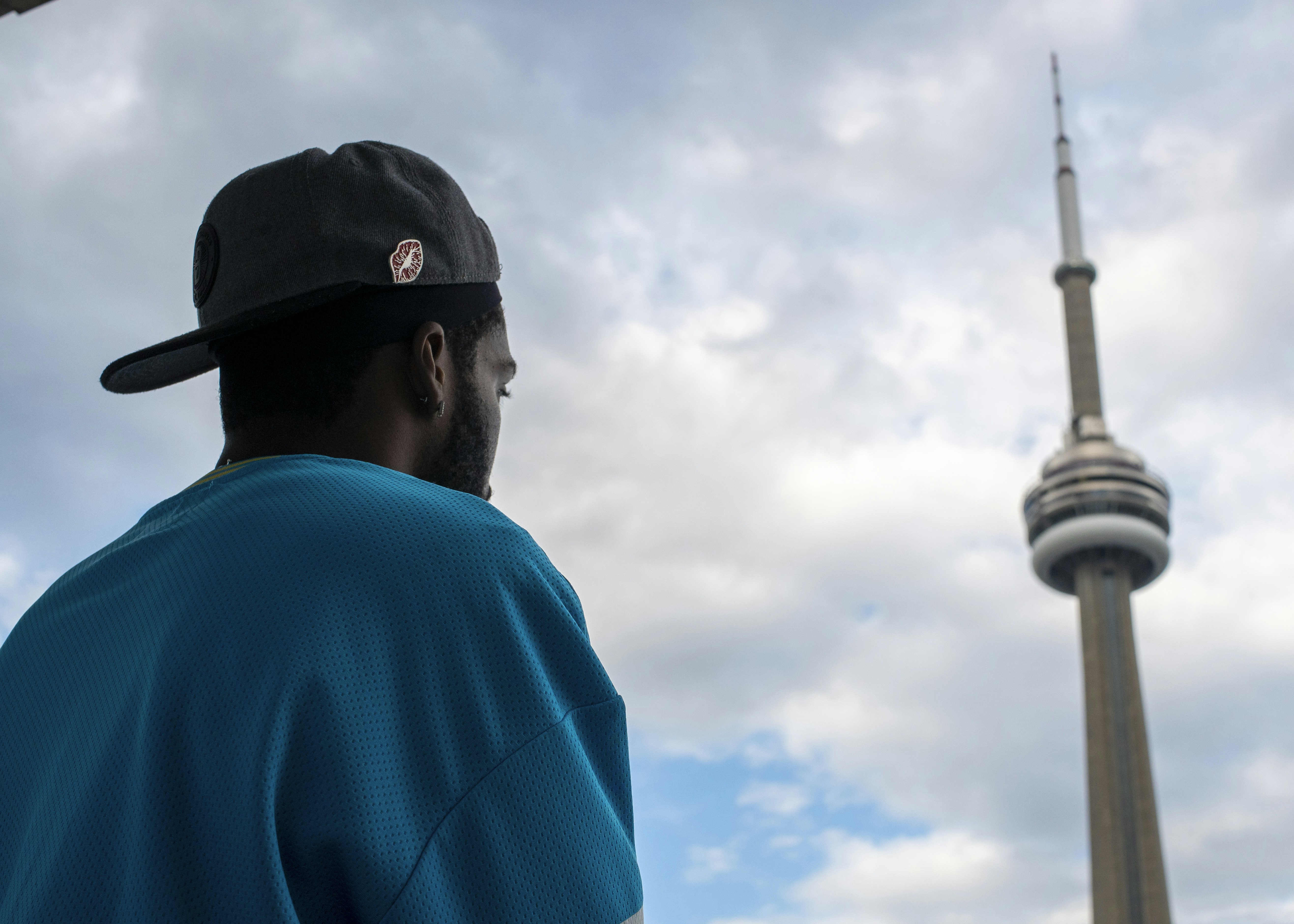 Man in blue shirt looks at cn tower