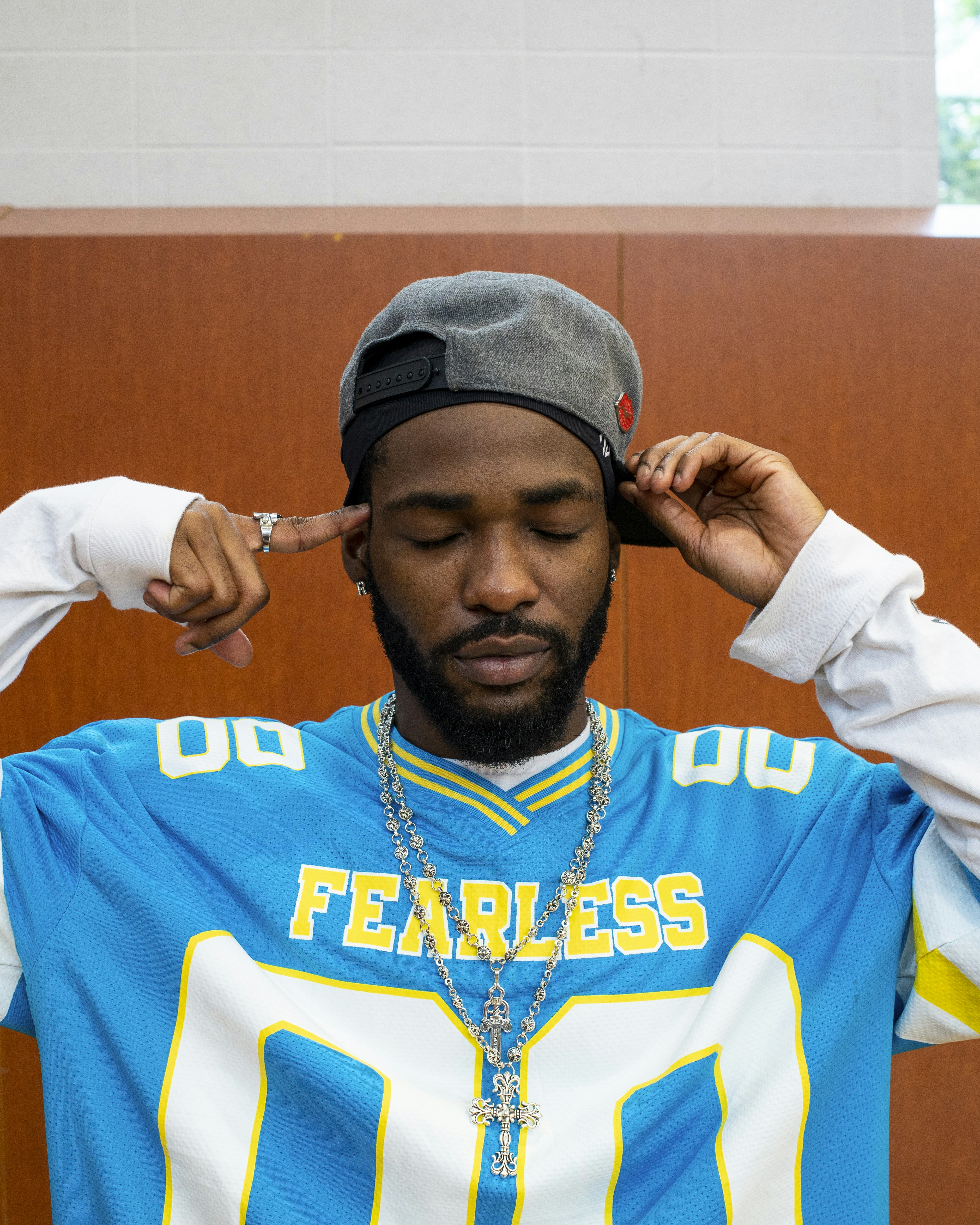 Mann im blauen Trikot rückt seine Baseballkappe zurecht.