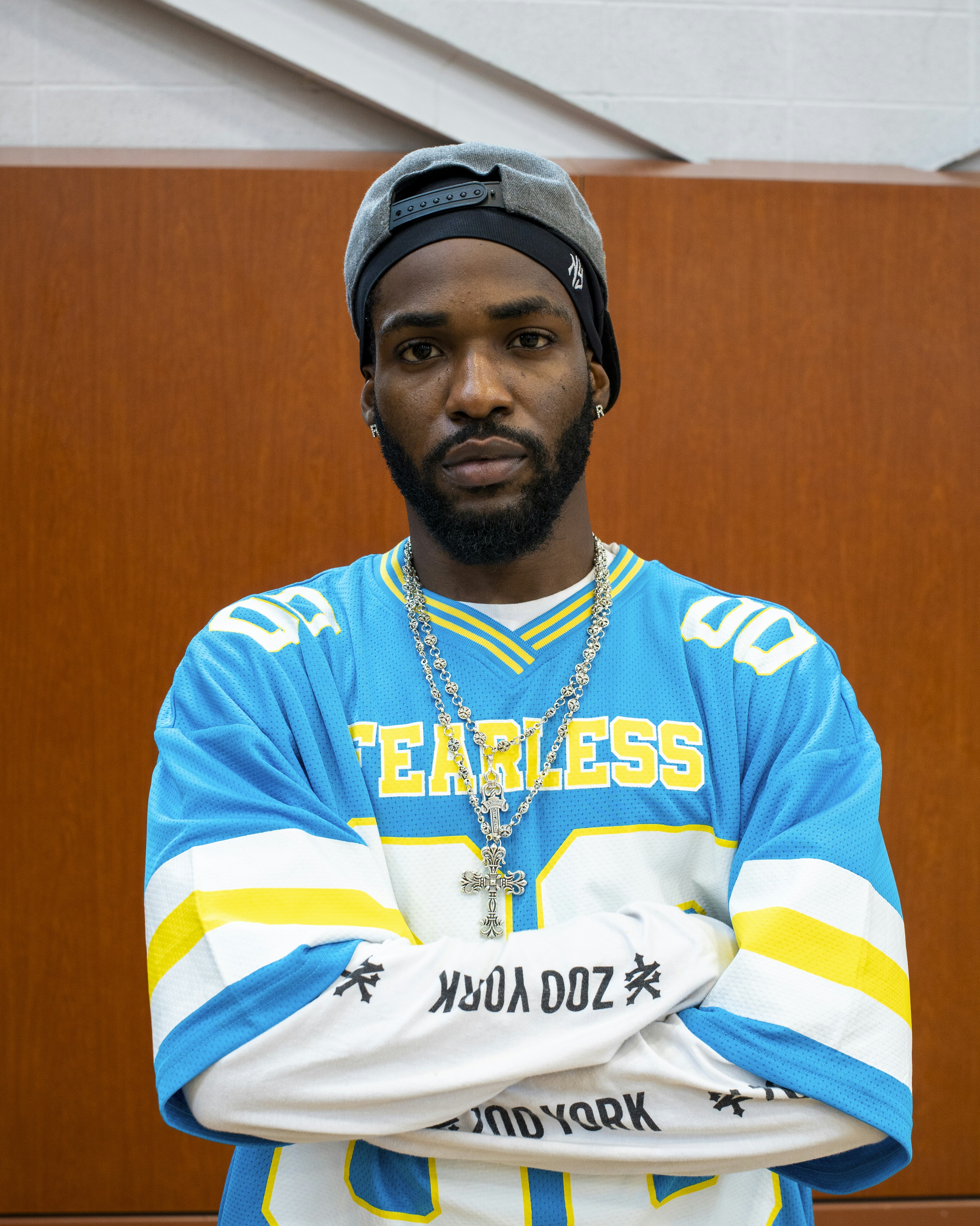 Man in blue and yellow jersey with arms crossed