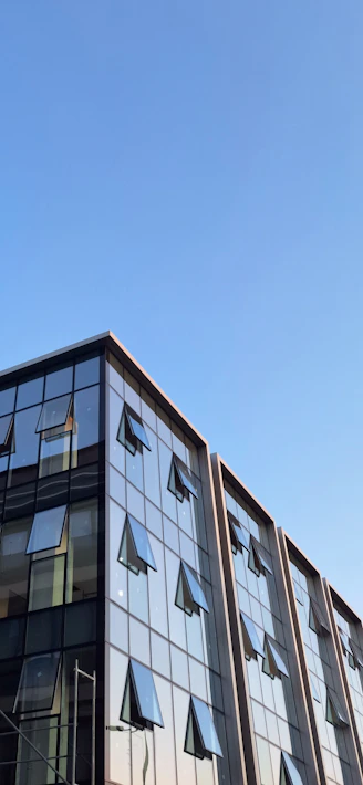 Modern building with open windows against blue sky