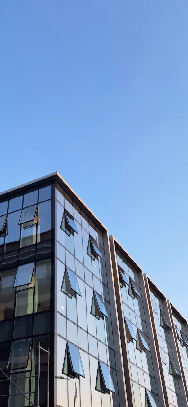 Modern building with open windows against blue sky