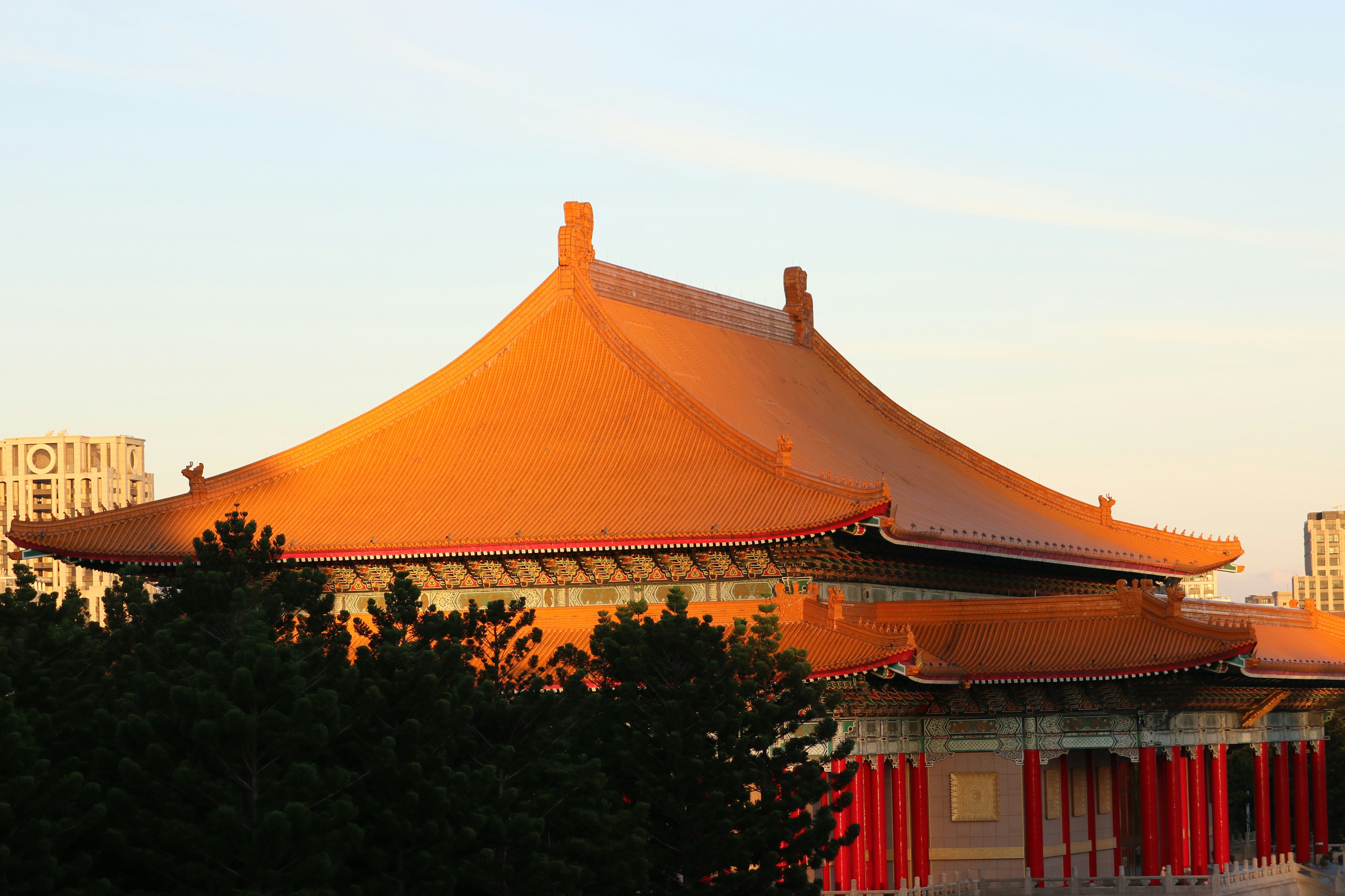 Traditional chinese building with orange roof at sunset.
