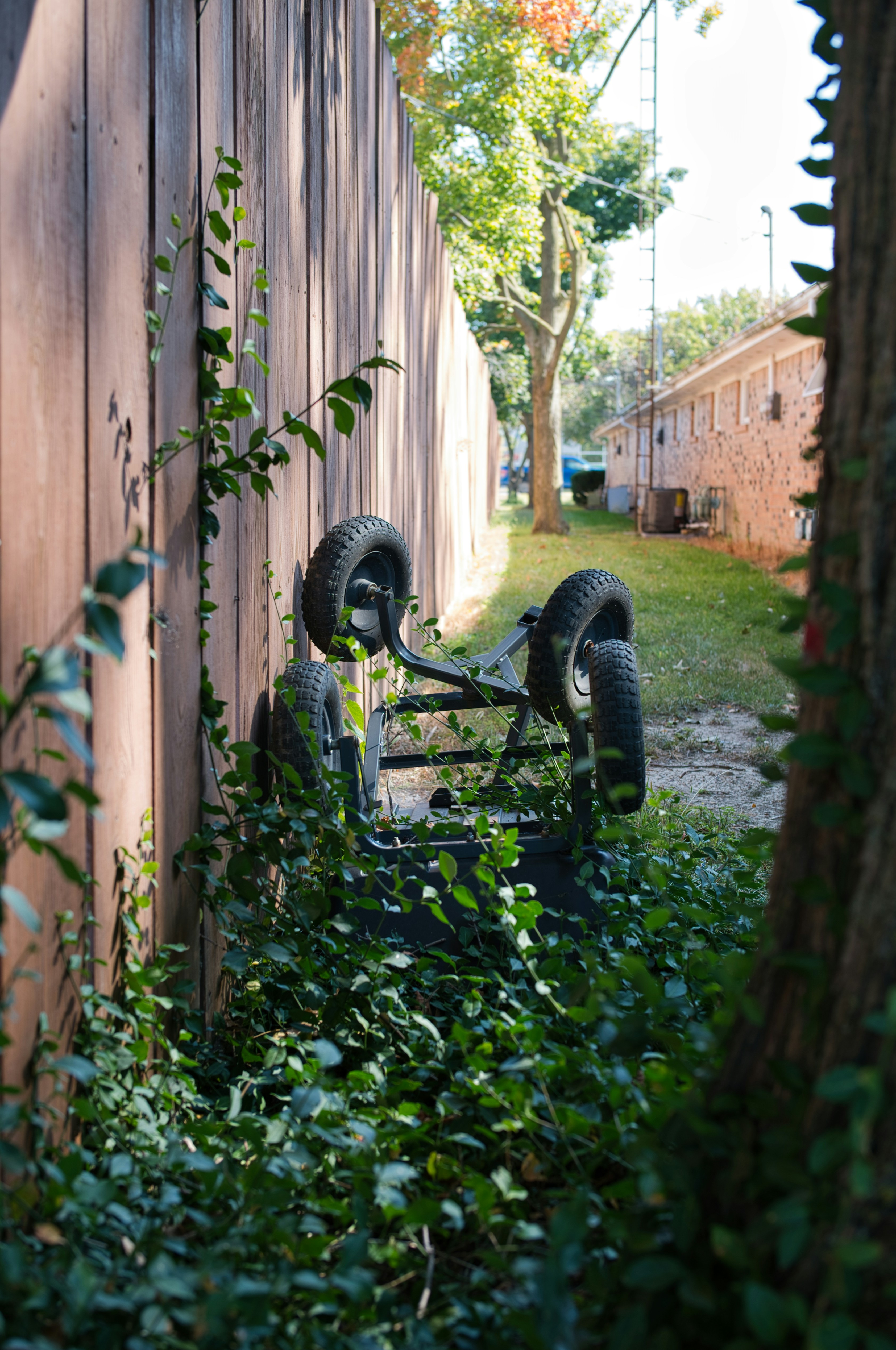 Overturned cart with wheels overgrown with vines