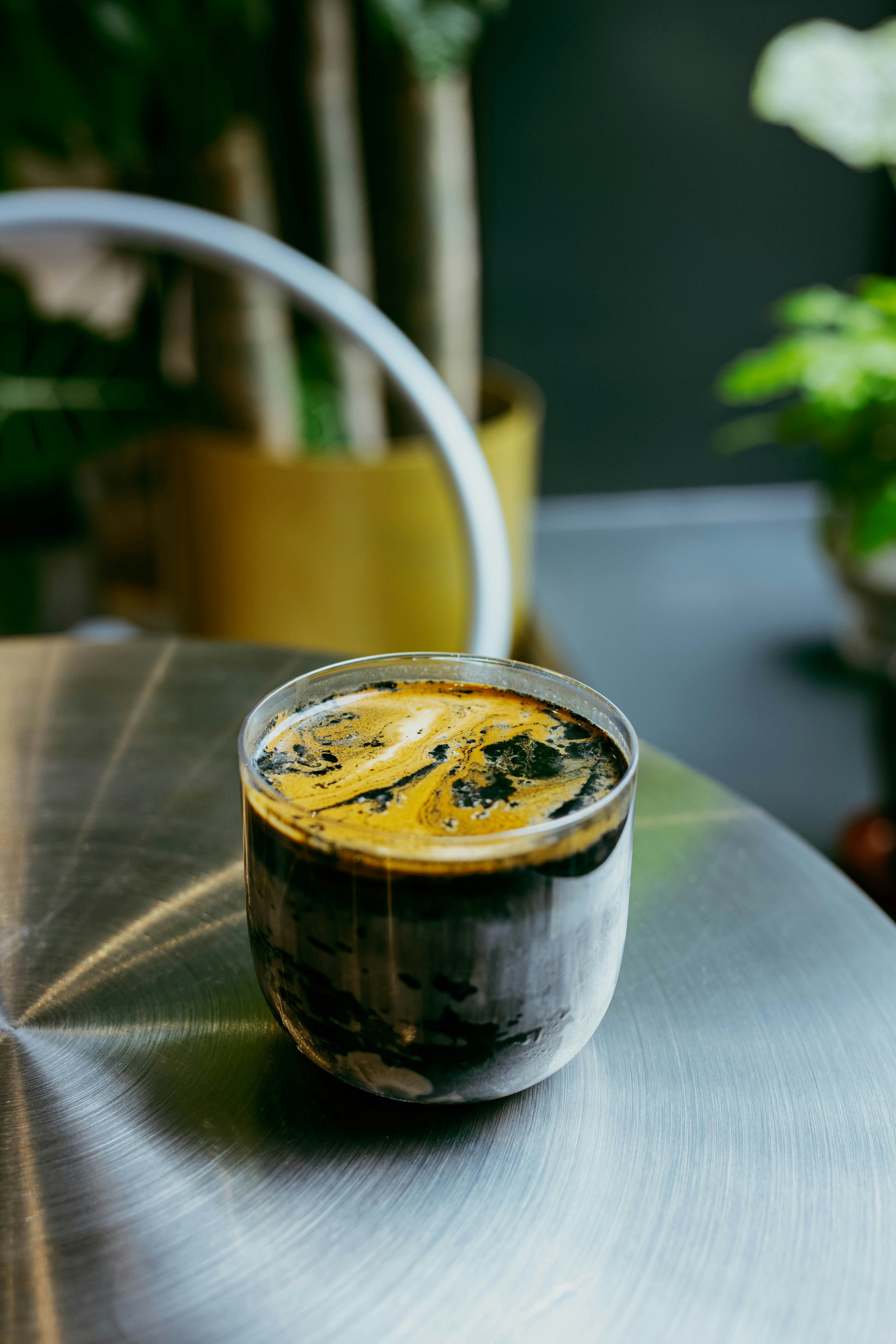 Espresso poured over ice with crema swirls.