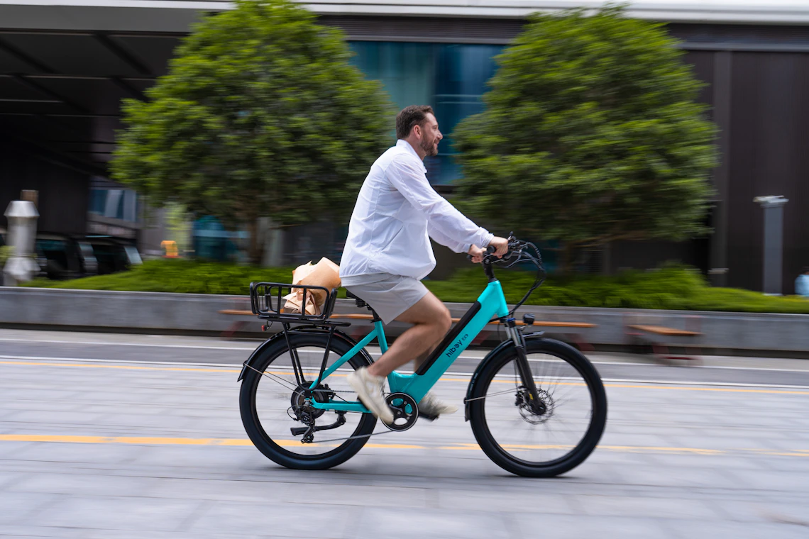 Rider using an electric bicycle fitted with a practical rear basket