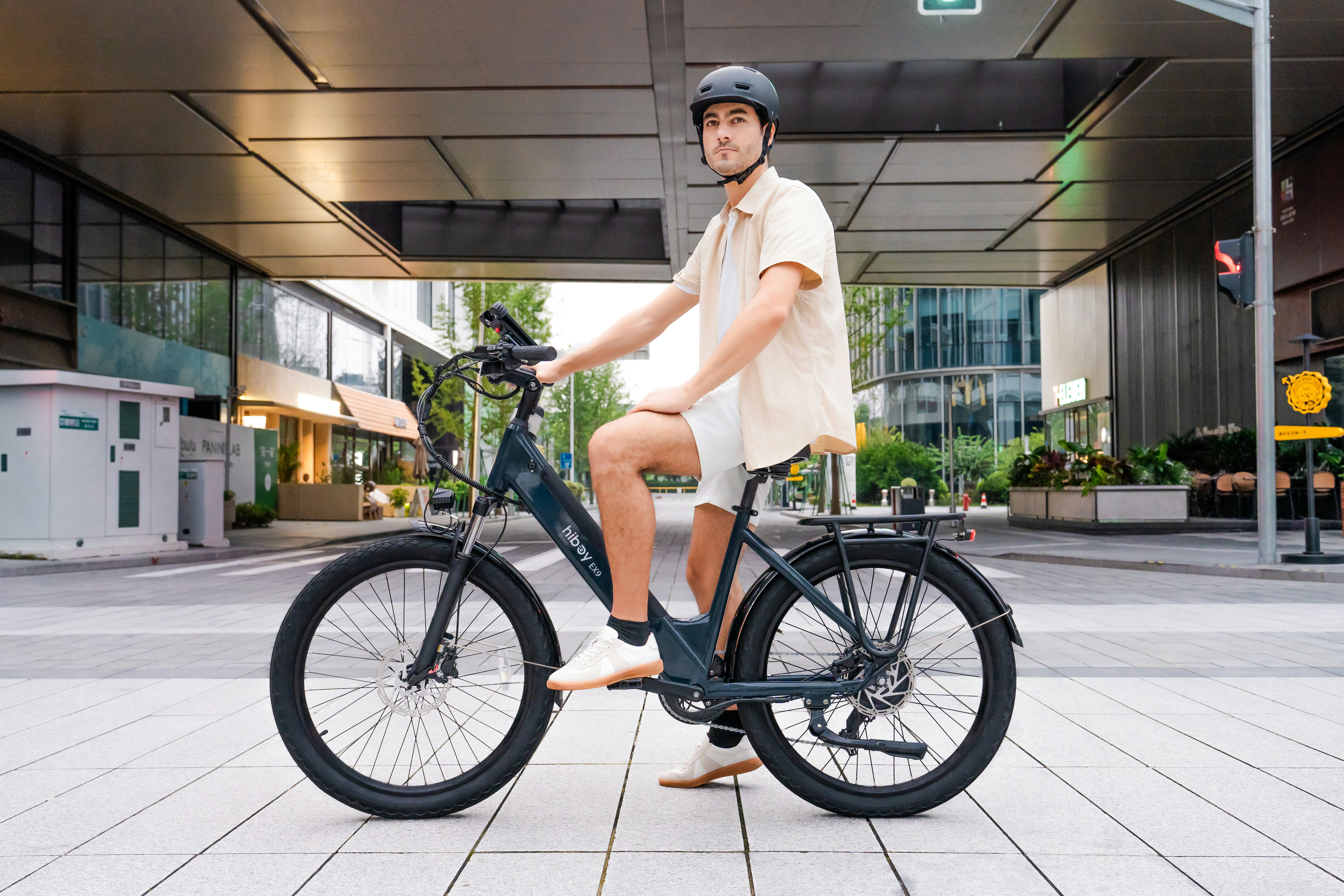 Man in helmet riding an electric bicycle outdoors.