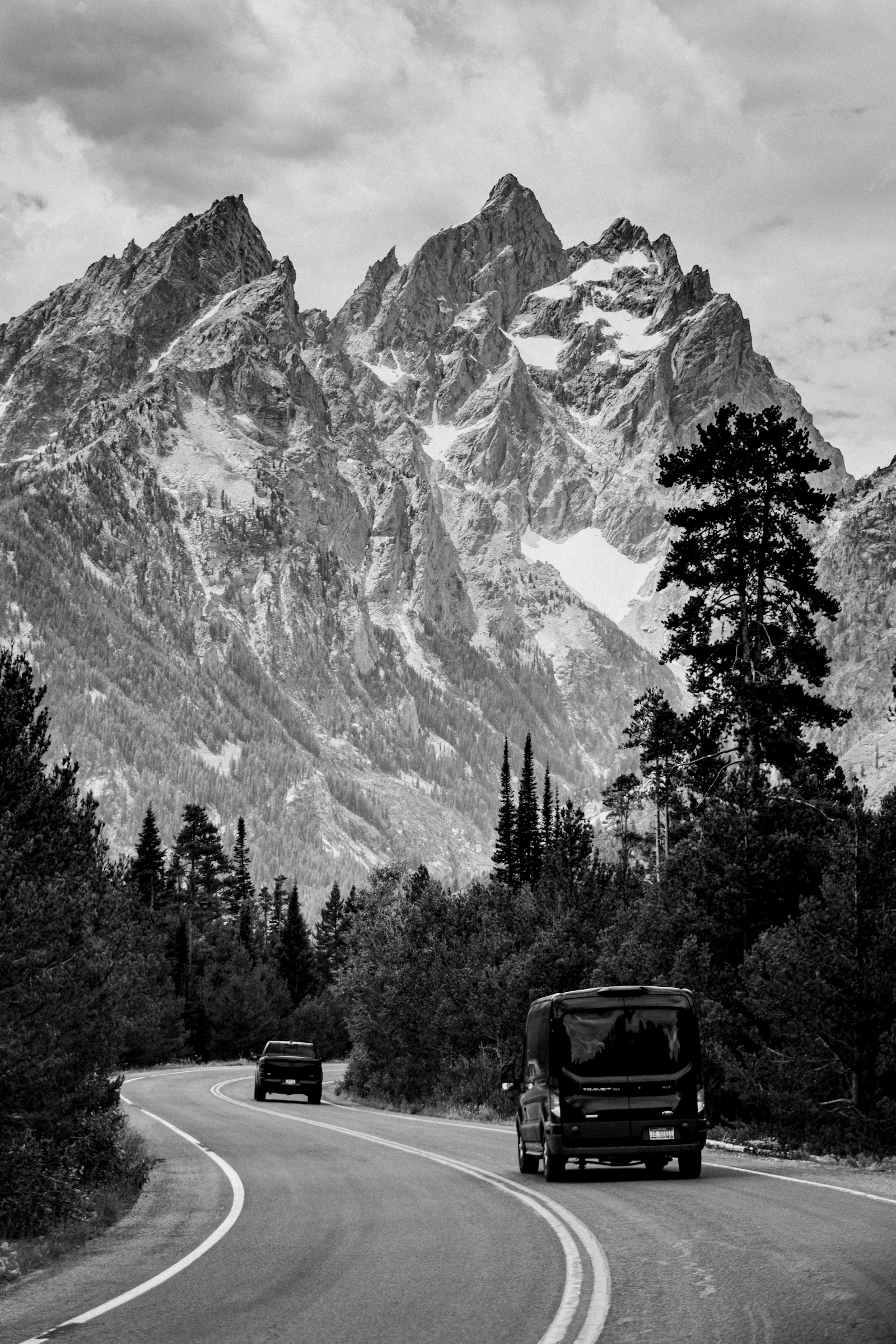 Vehicles travel toward the mountains in Grand Teton National Park