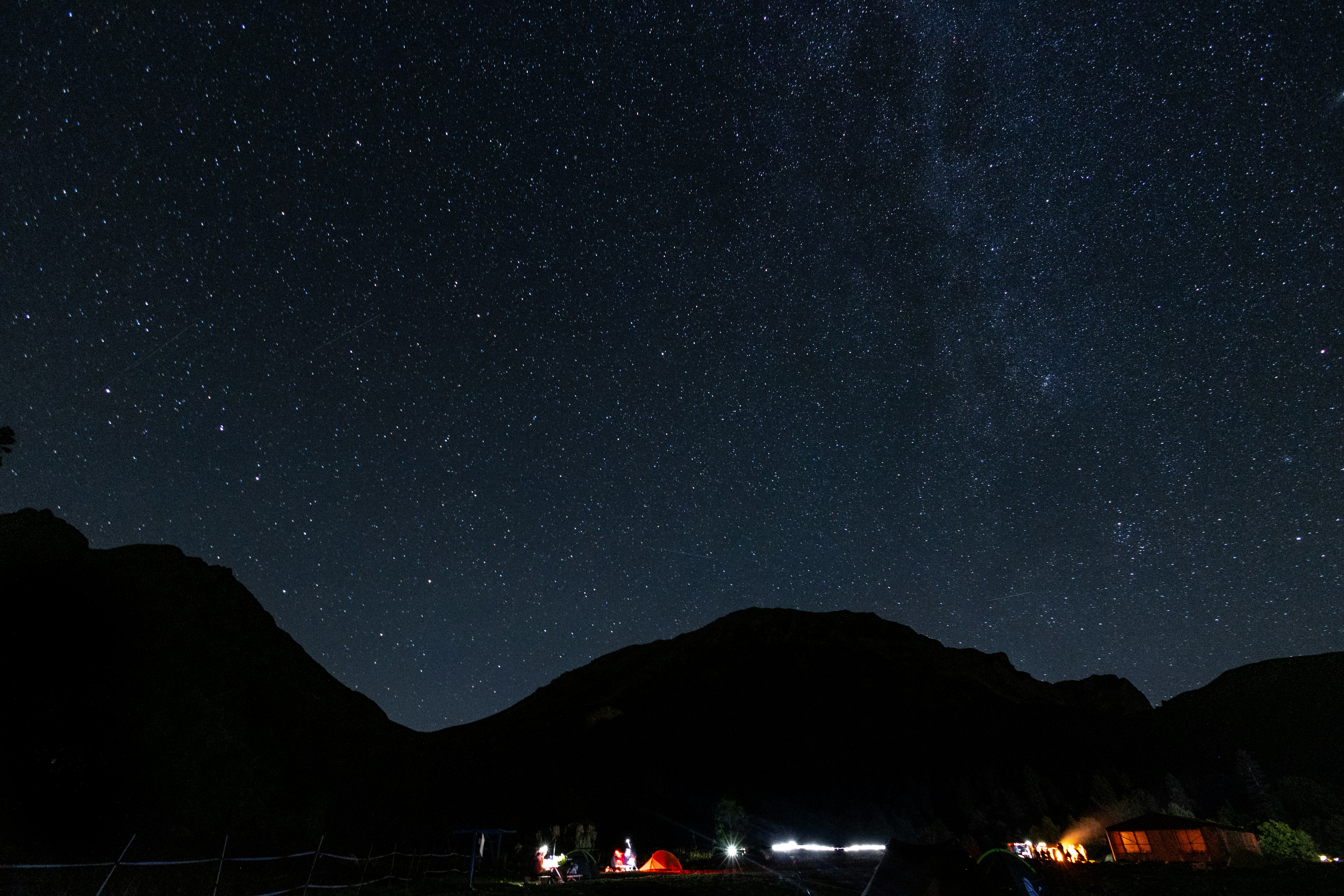 سماء ليلية مليئة بالنجوم فوق جبال مظللة