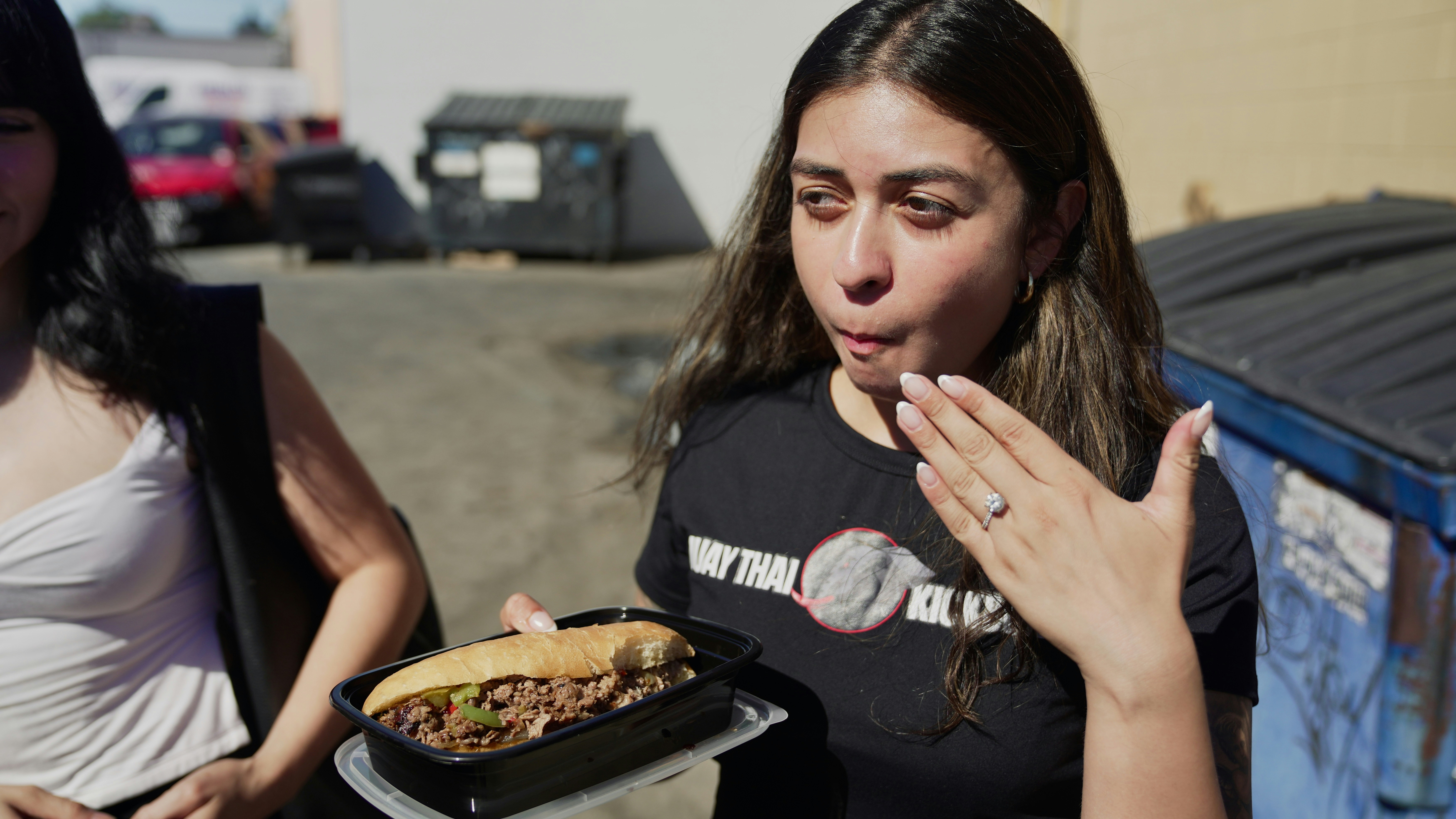 Woman holding a large sandwich with both hands.