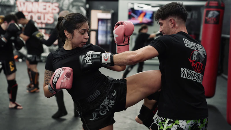 Muay Thai student practicing pad work with a coach