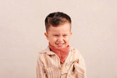 A young boy makes a funny face with a bandana.