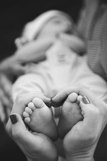 Parent's hands form heart around baby's feet