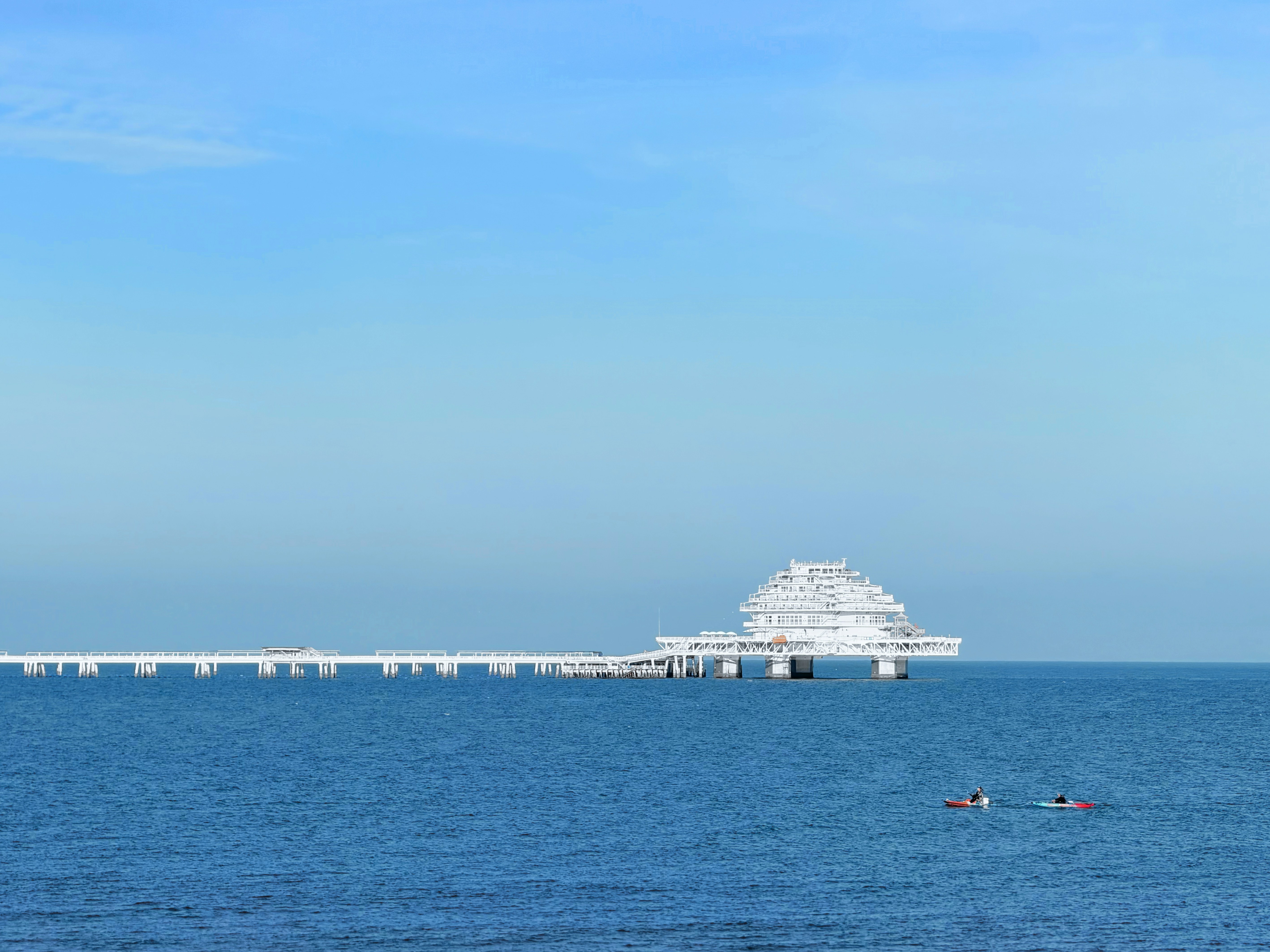 Moderner Pier, der sich in den ruhigen blauen Ozean erstreckt.