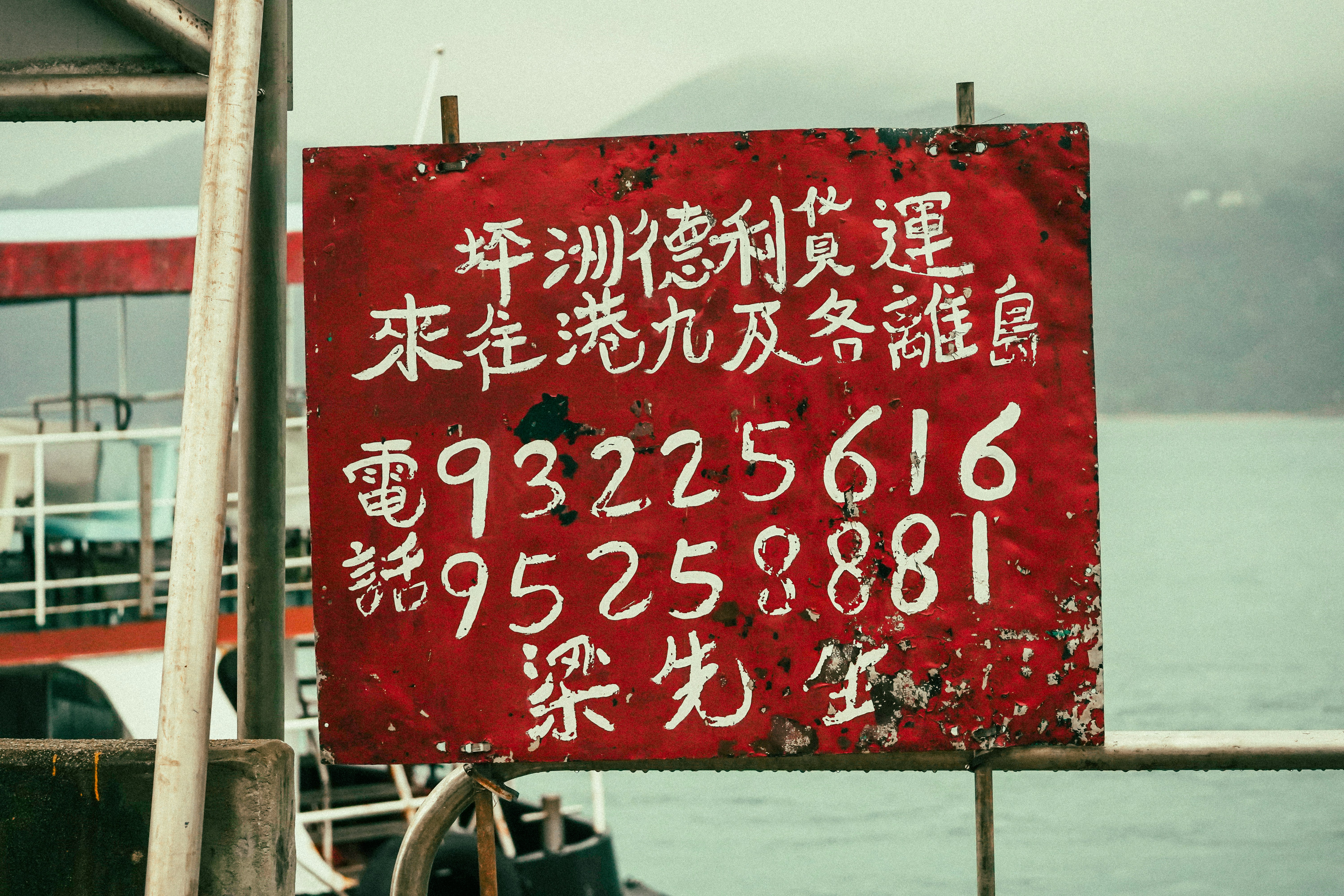 Red sign with chinese text and phone numbers