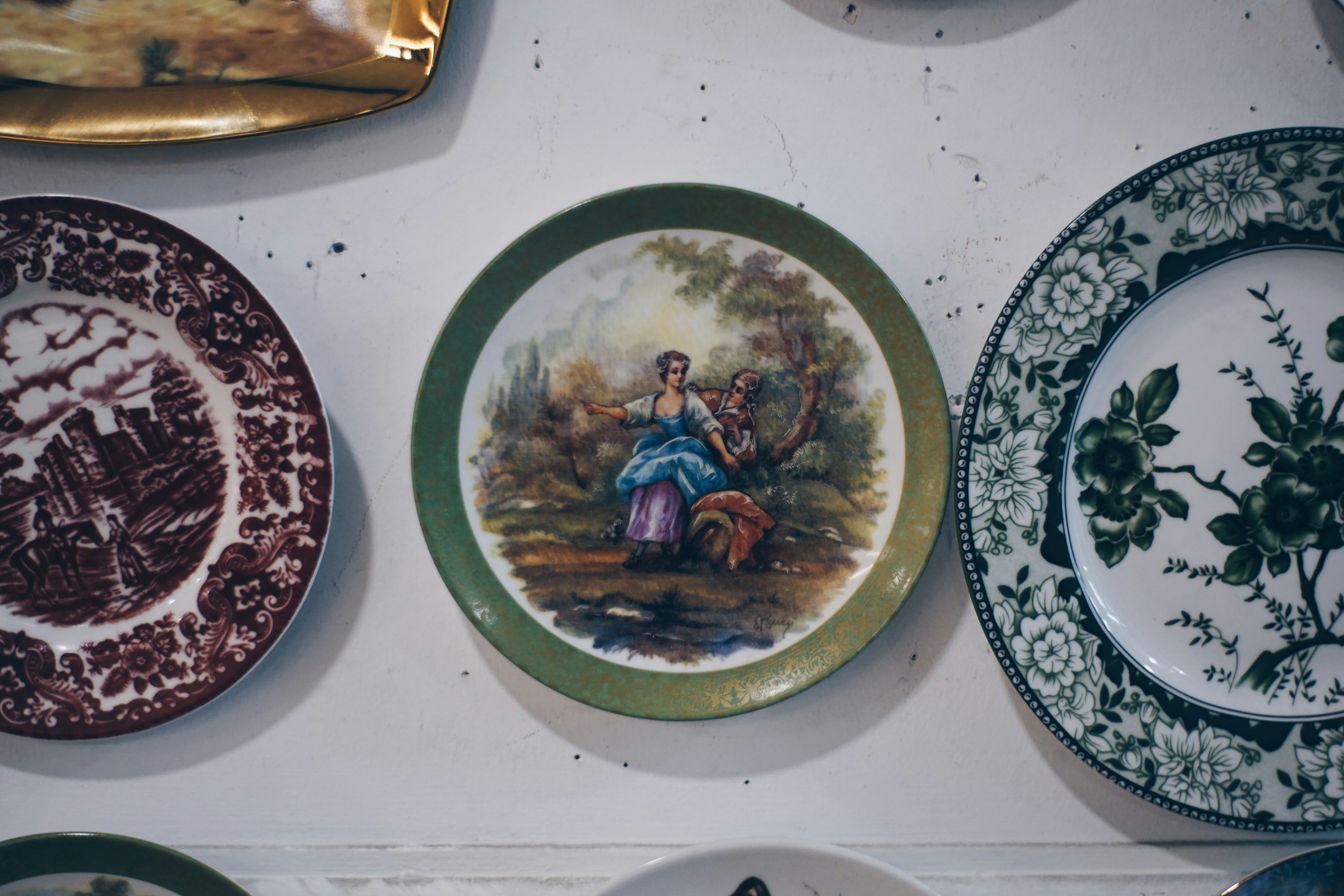Sammlung von dekorativen Tellern mit gemalten Szenen.