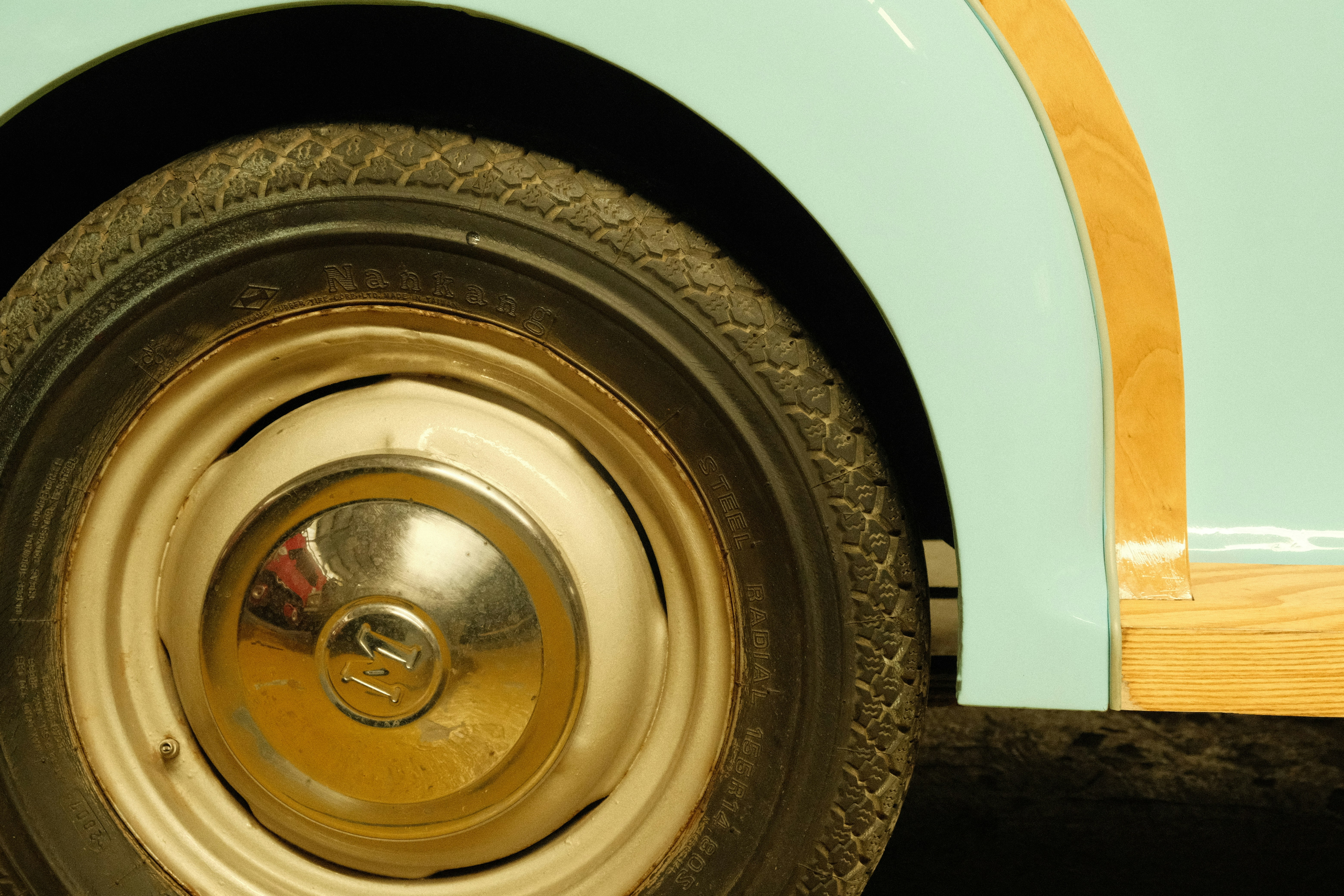 Close-up of a vintage car wheel and fender.