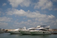 Luxury yachts docked in a marina under blue sky.