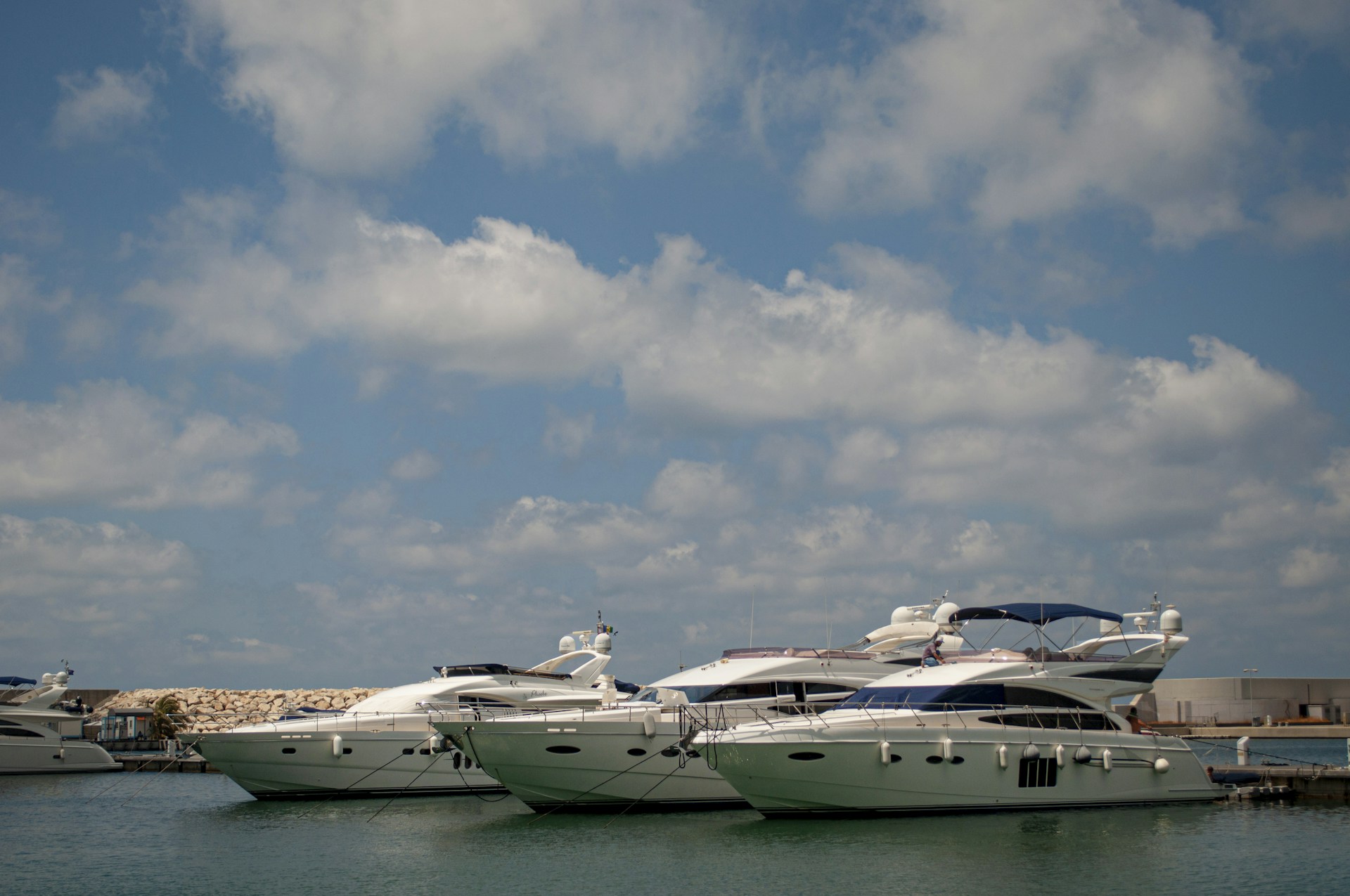 Luxury yachts docked in a marina under blue sky.