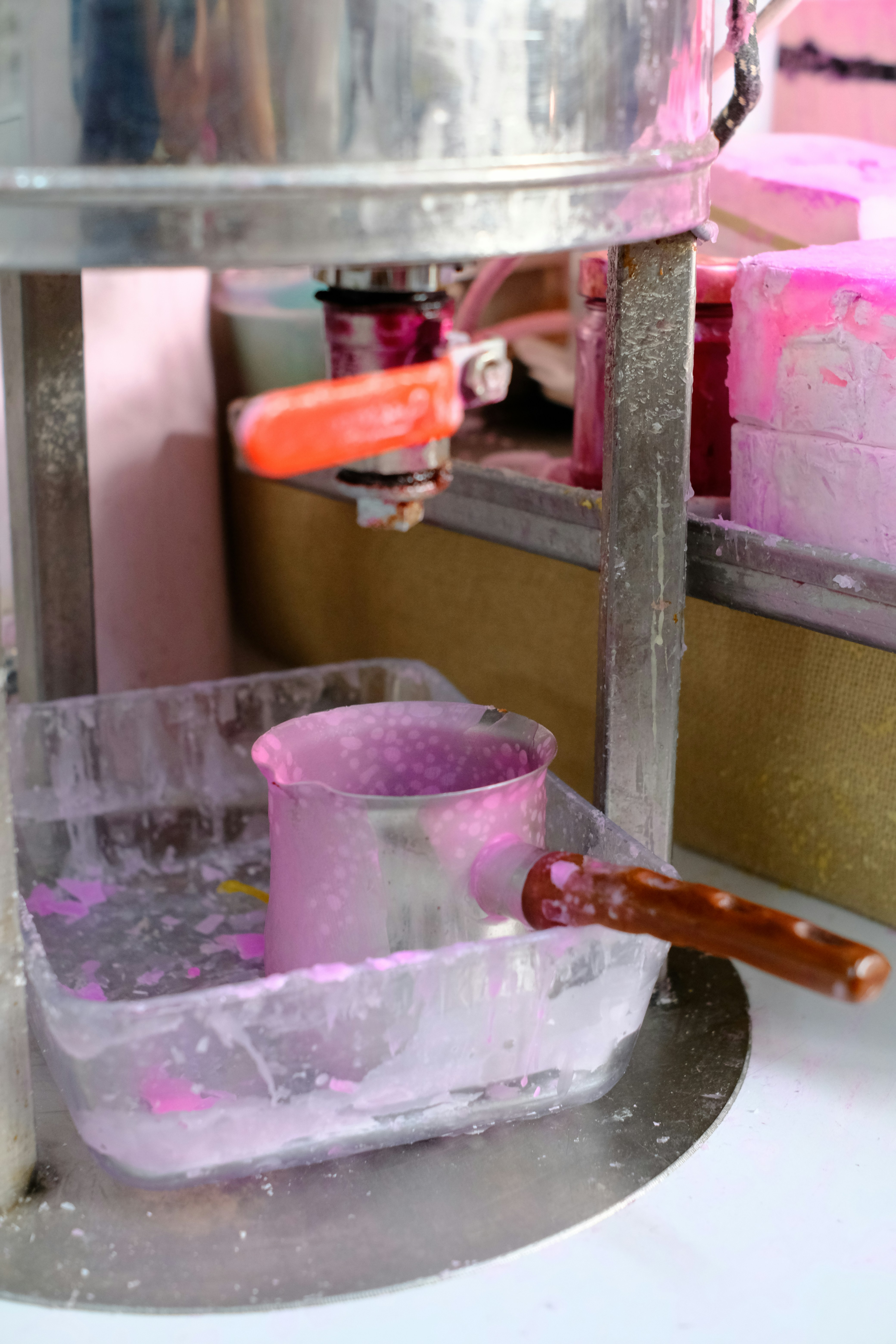 Pink liquid in a metal container with a handle