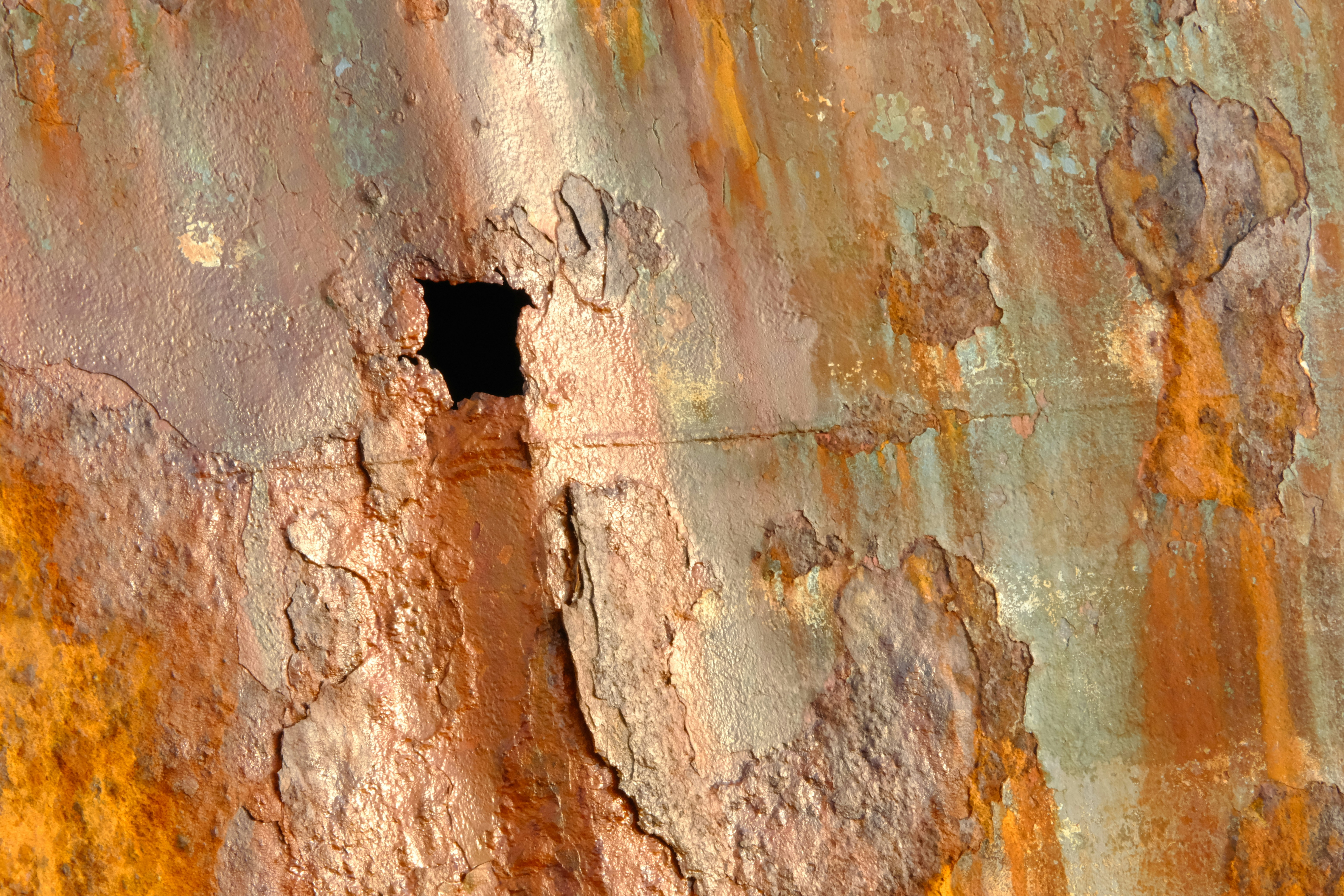 Close-up of rusty metal with a square hole.