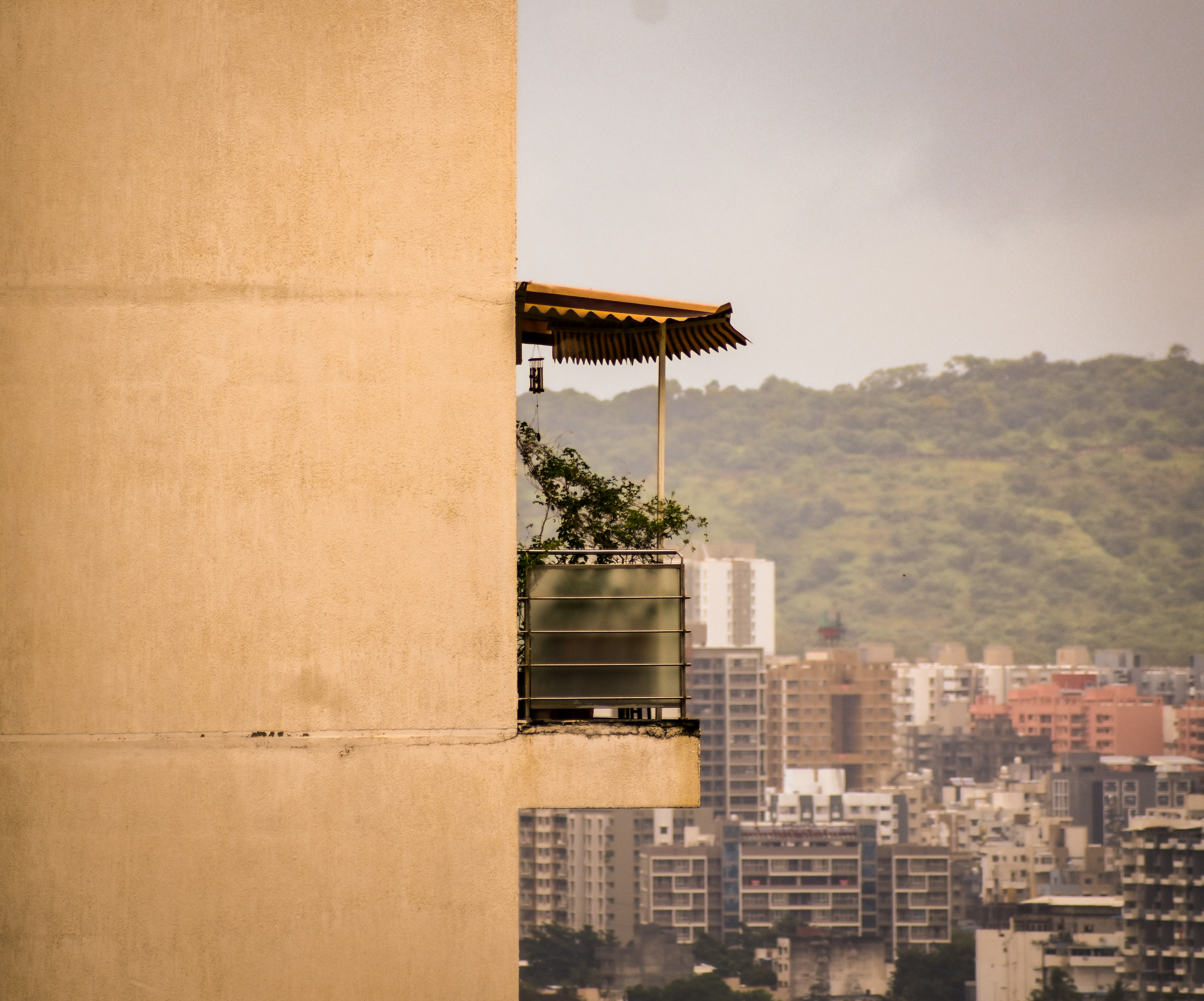 Balcony overlooks a hazy cityscape with mountains beyond