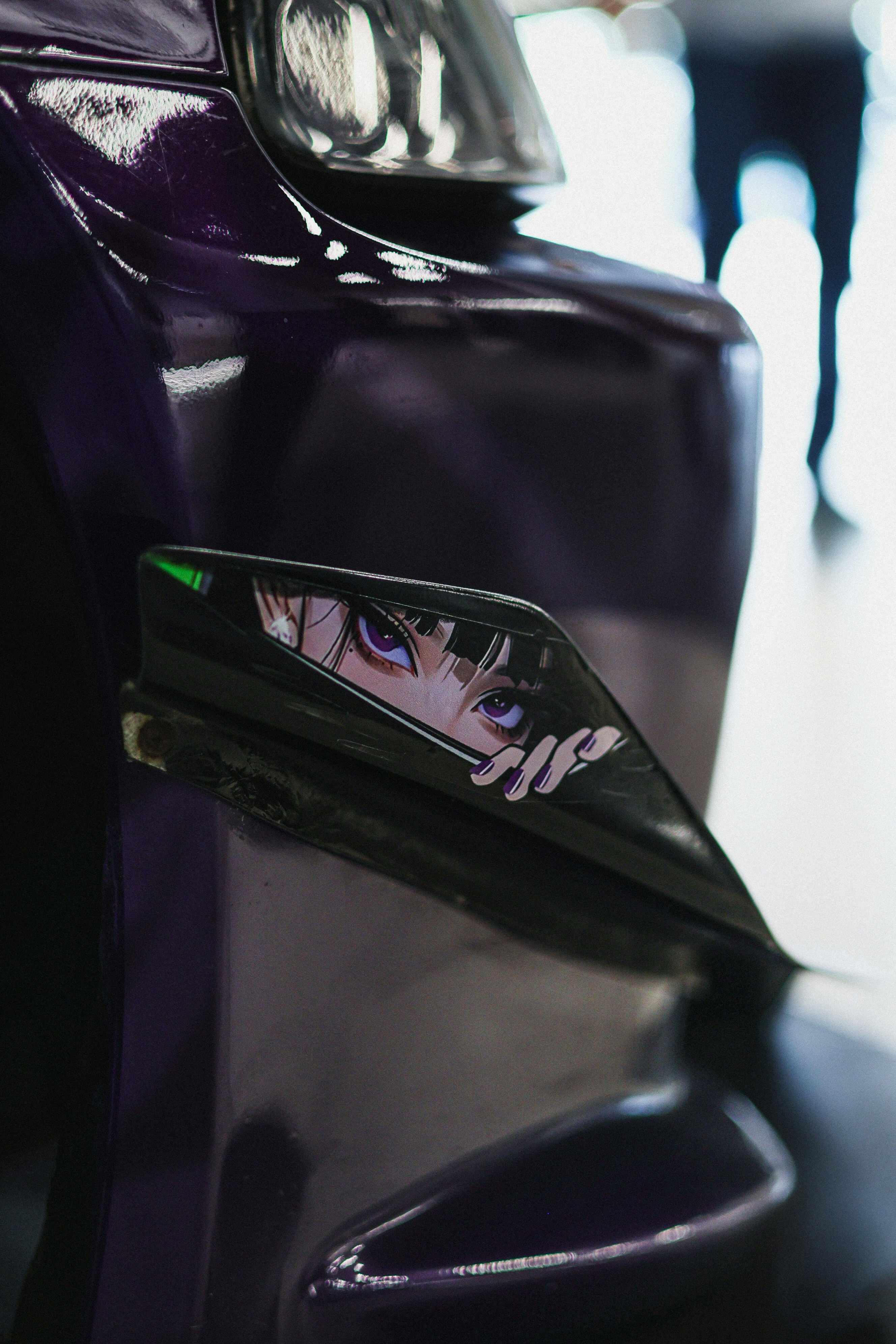 Anime eyes sticker on a purple car fender
