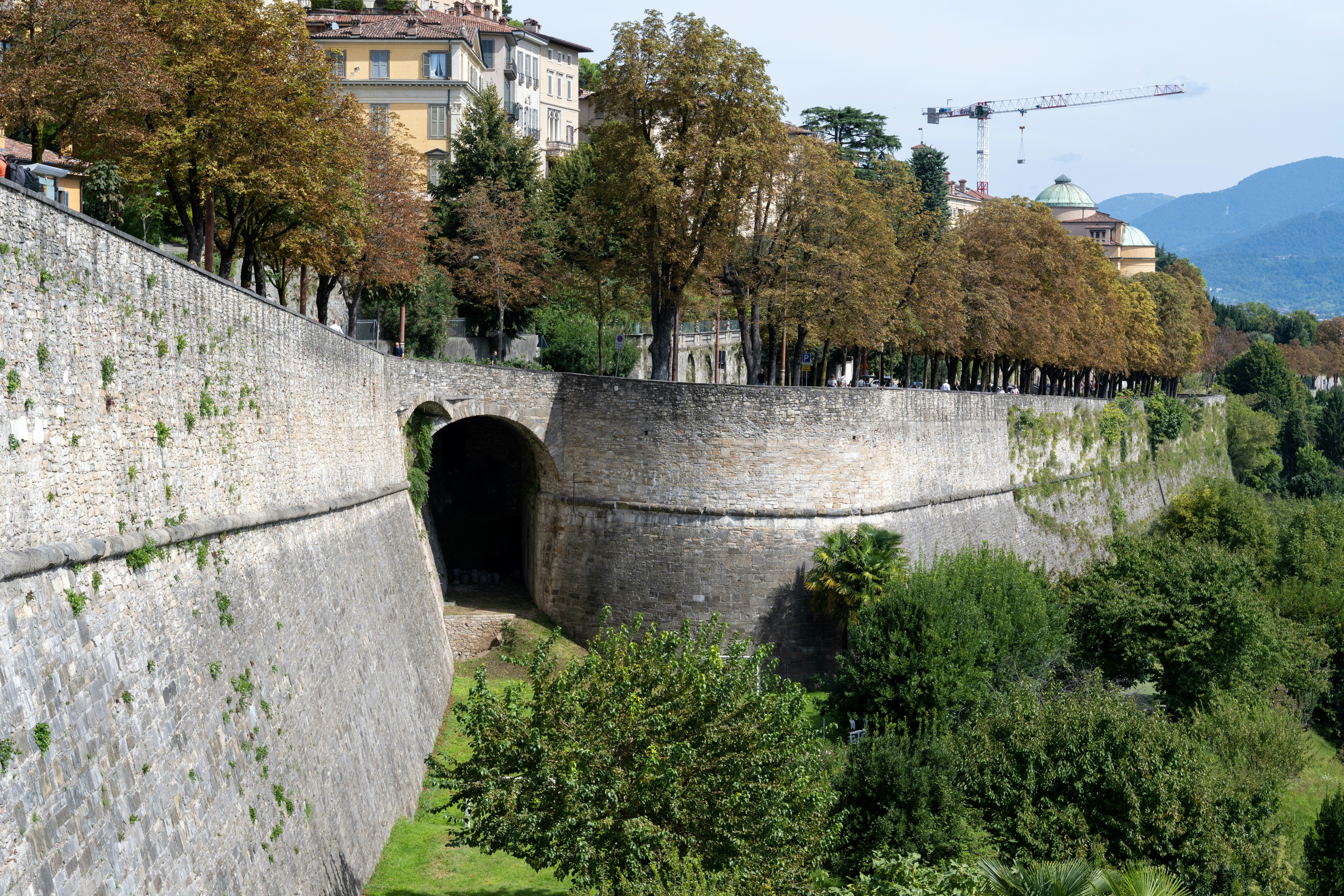 Ancient stone walls with an archway and trees.