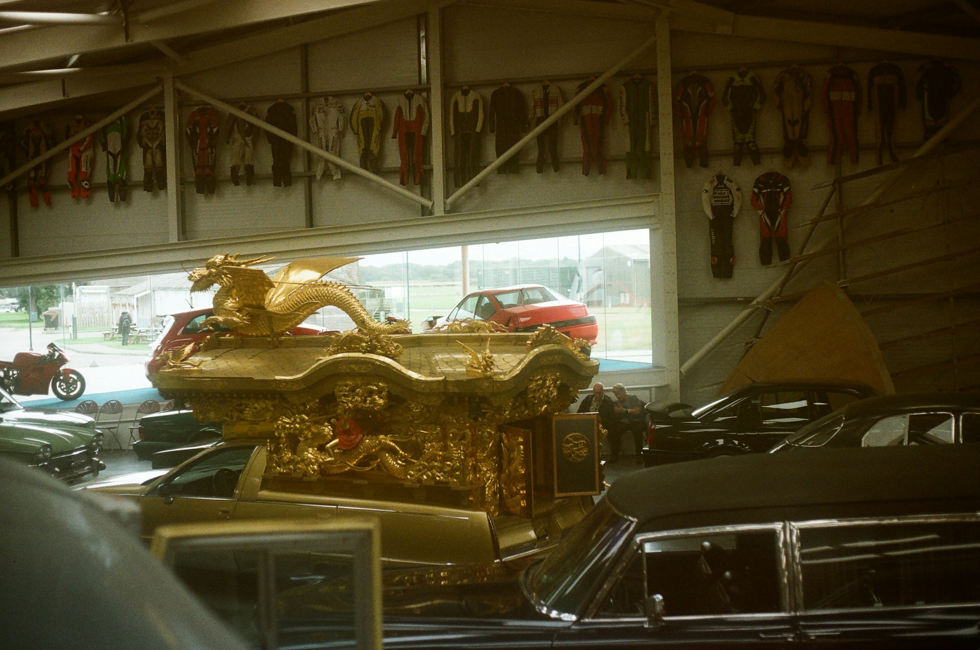 Ornate golden sculpture atop a vehicle in a garage.