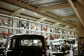 Vintage cars and motorcycles displayed in a museum.