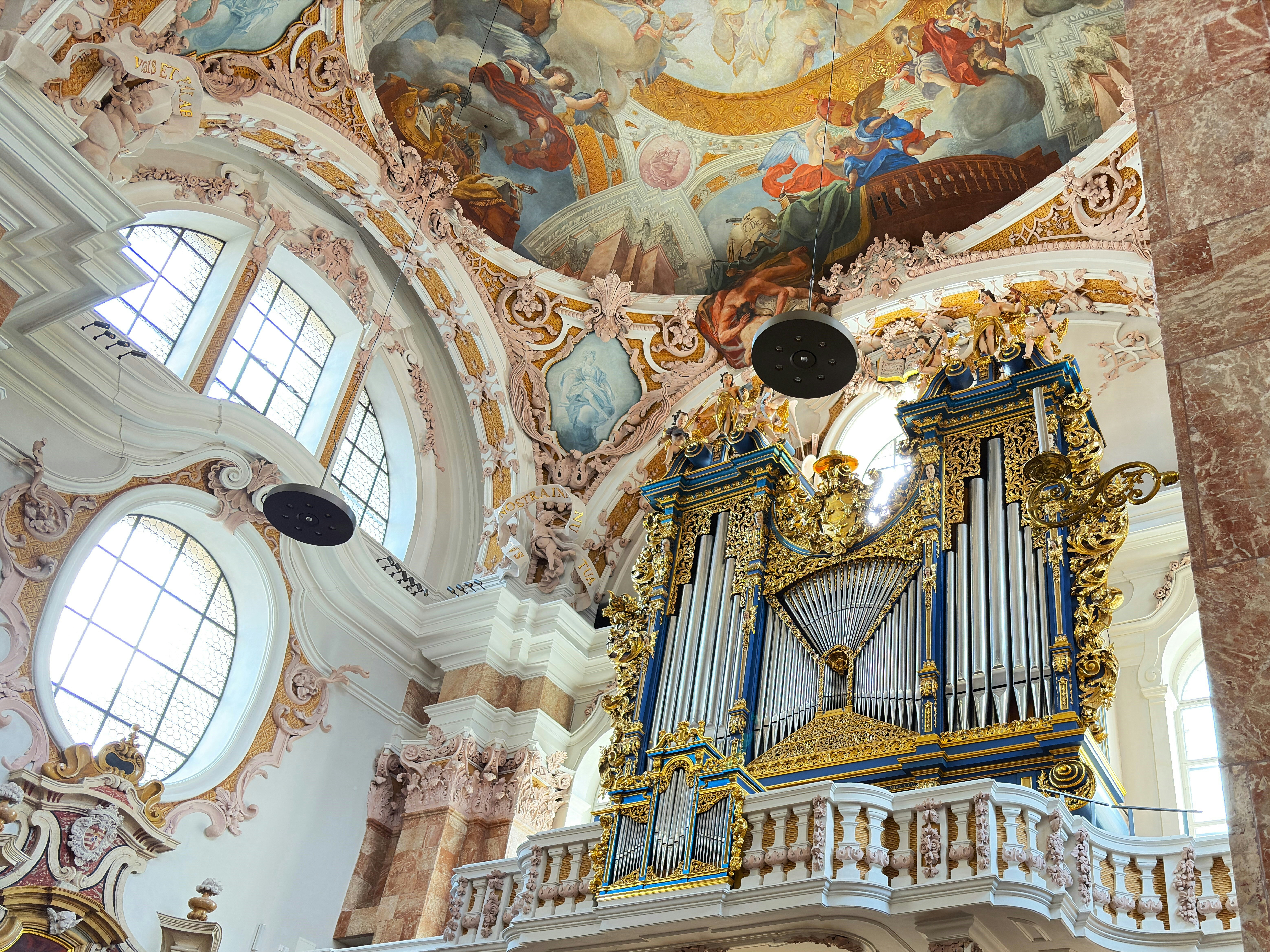 Ornate pipe organ in a grand church interior.