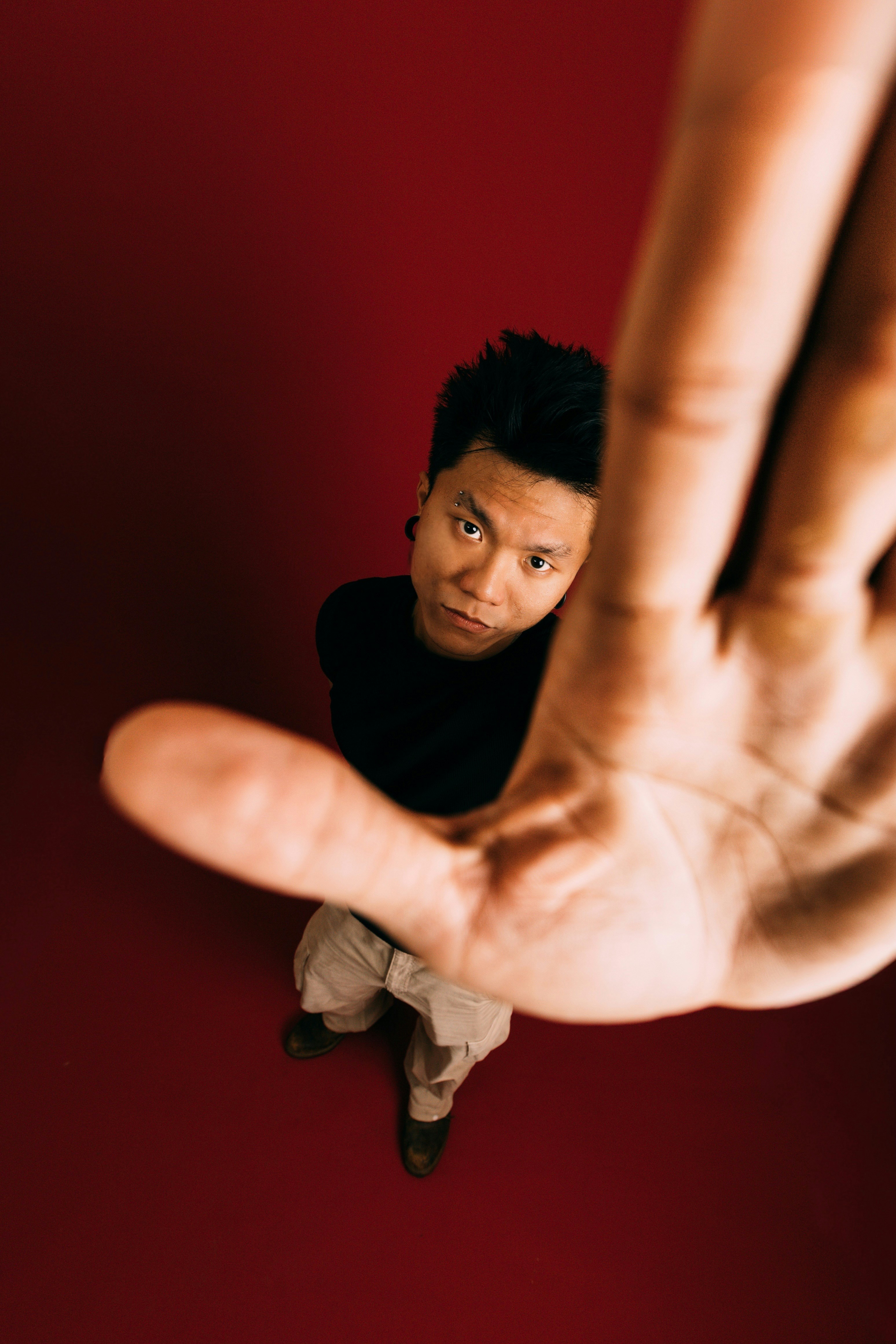 Man holds hand up against the camera. photo – Free Red background Image ...