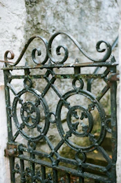 Ornate wrought iron gate with decorative circular patterns.