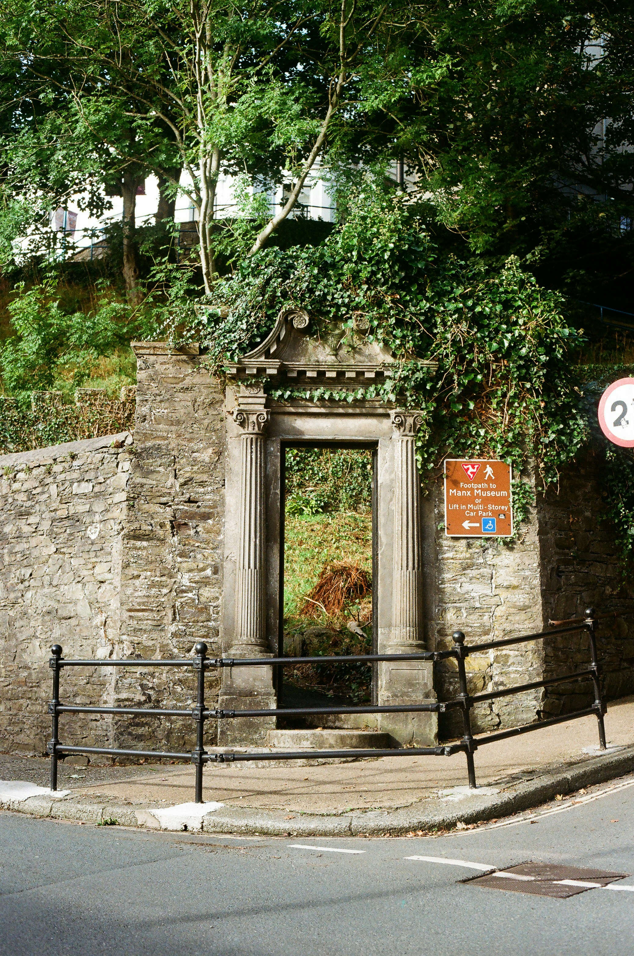 Stone gateway with overgrown ivy and greenery