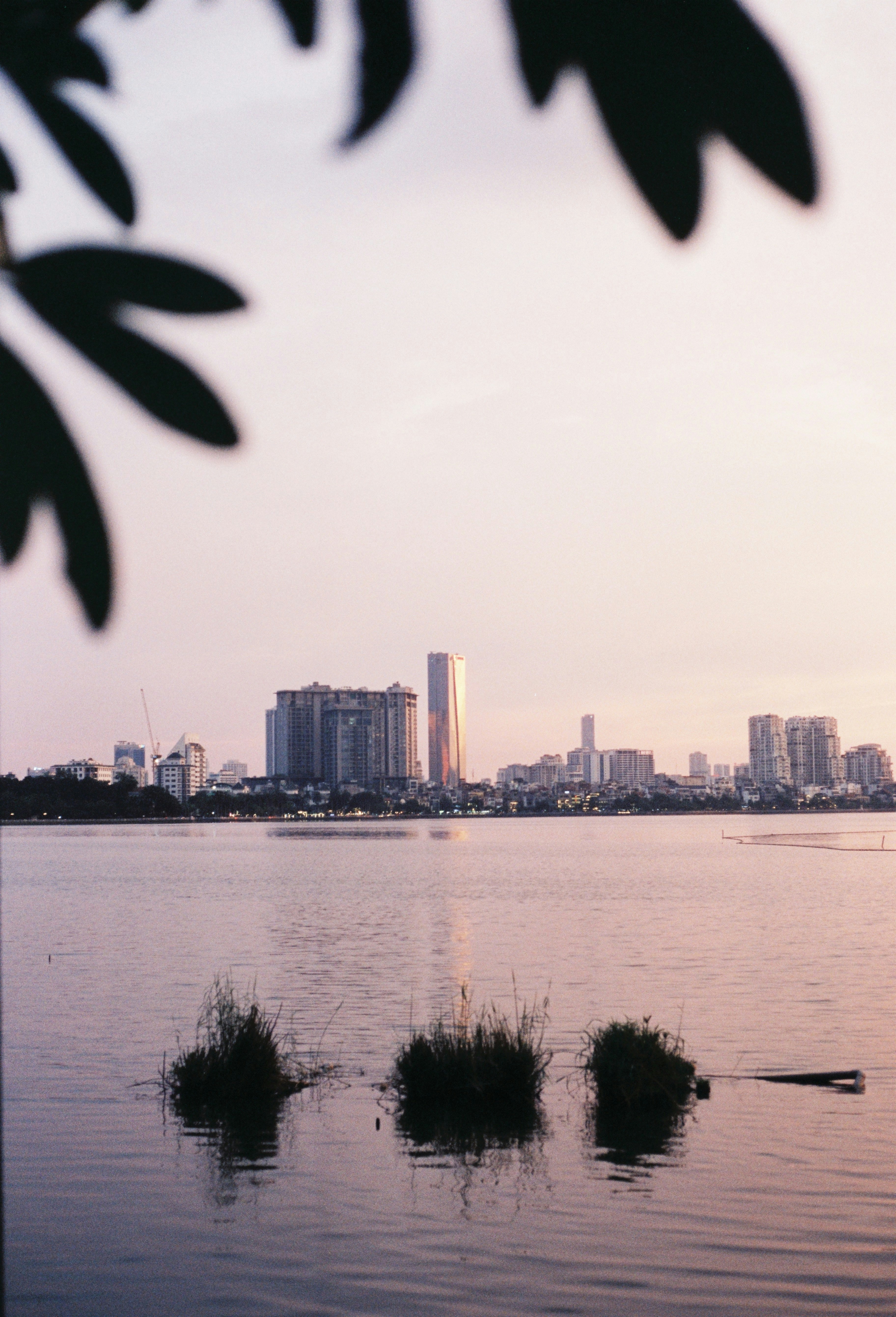 City skyline reflected in calm water at sunset