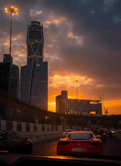 Cars on highway with city skyline at sunset