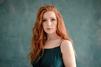 Young woman with long red hair and green dress.