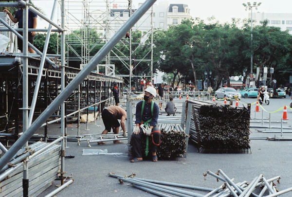 Workers assembling frame scaffolding on a building site