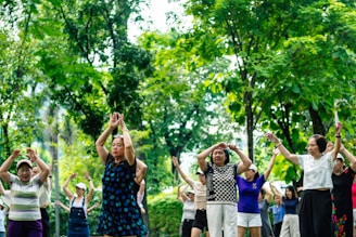 Seniors exercising together outdoors in a park.