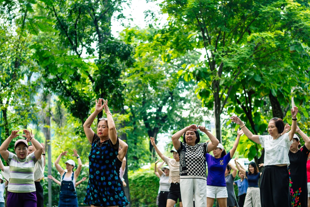 Seniors exercising together outdoors in a park.