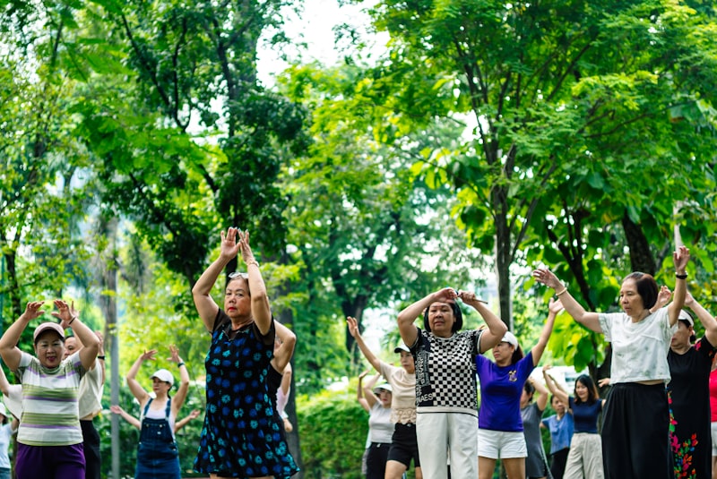 Seniors exercising together outdoors in a park practicing gentle movements for flexibility and balance
