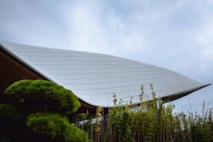 Modern building with curved roof and lush greenery