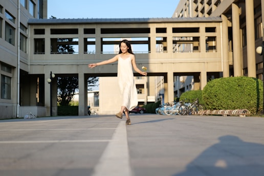Woman in white dress walking on a pathway.