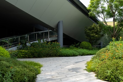 Modern building with lush green landscaping and walkway.