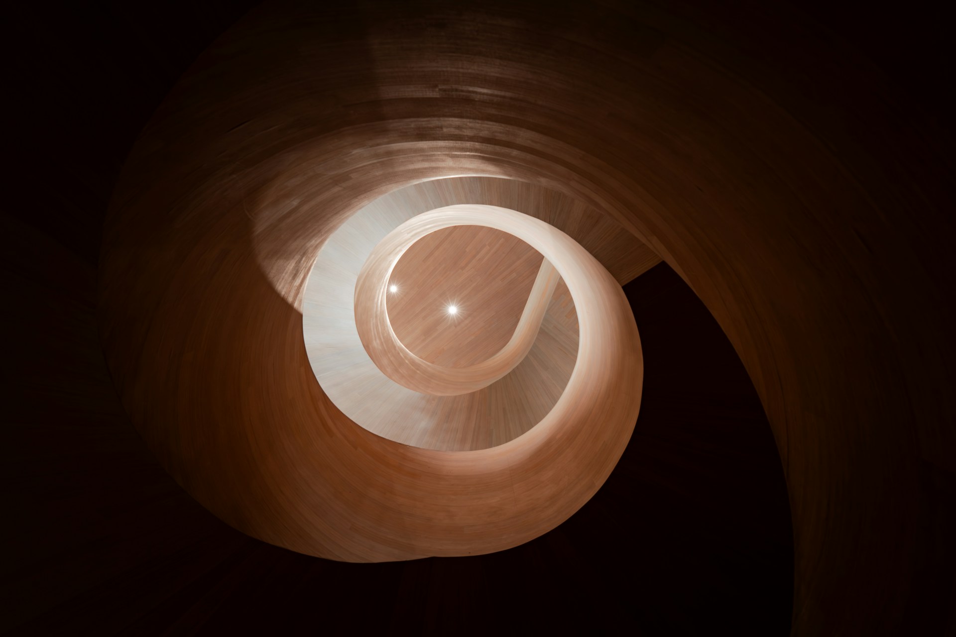 Spiral staircase with warm lighting and dark background