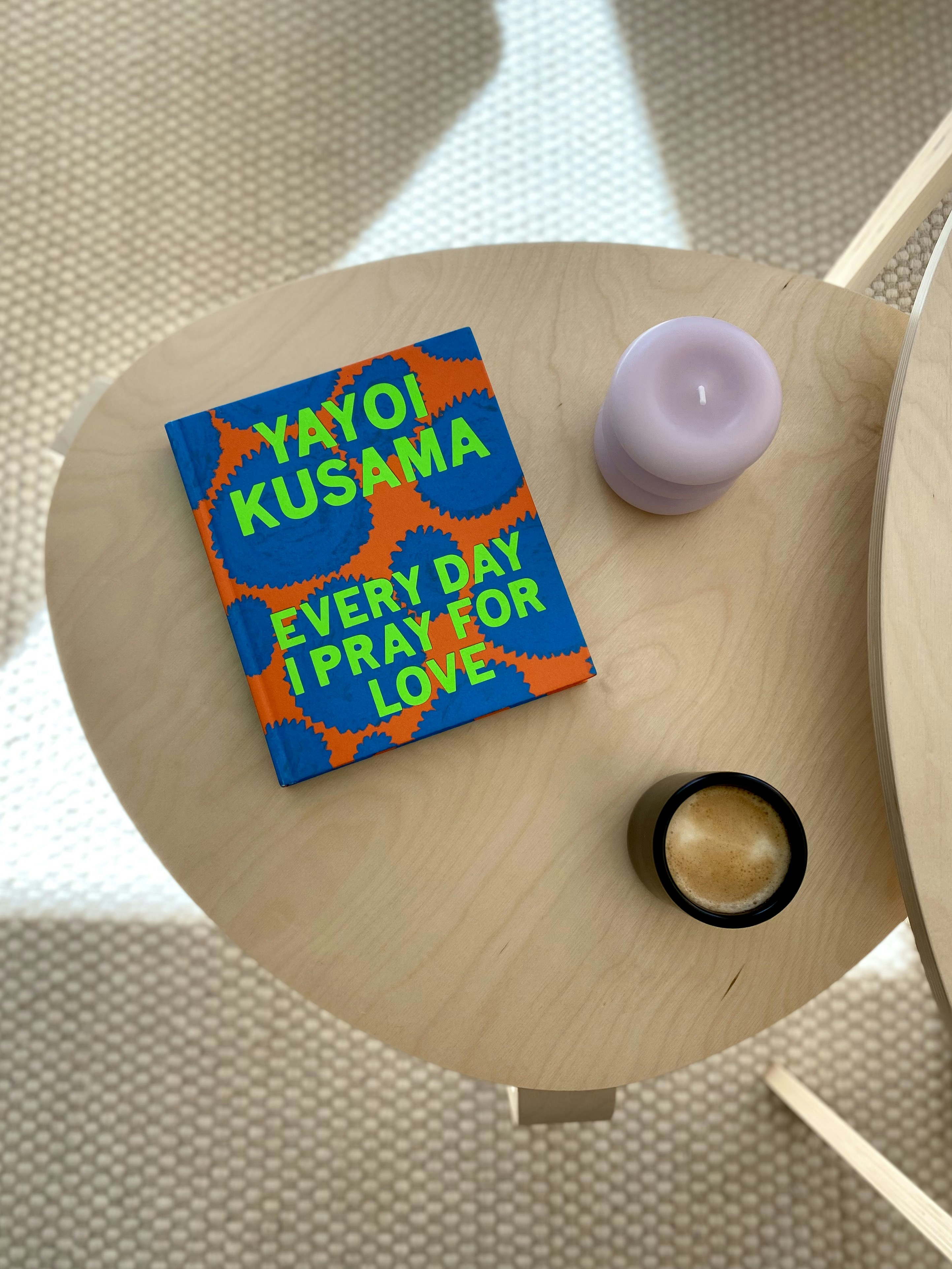 Book by yayoi kusama with candle and small container.