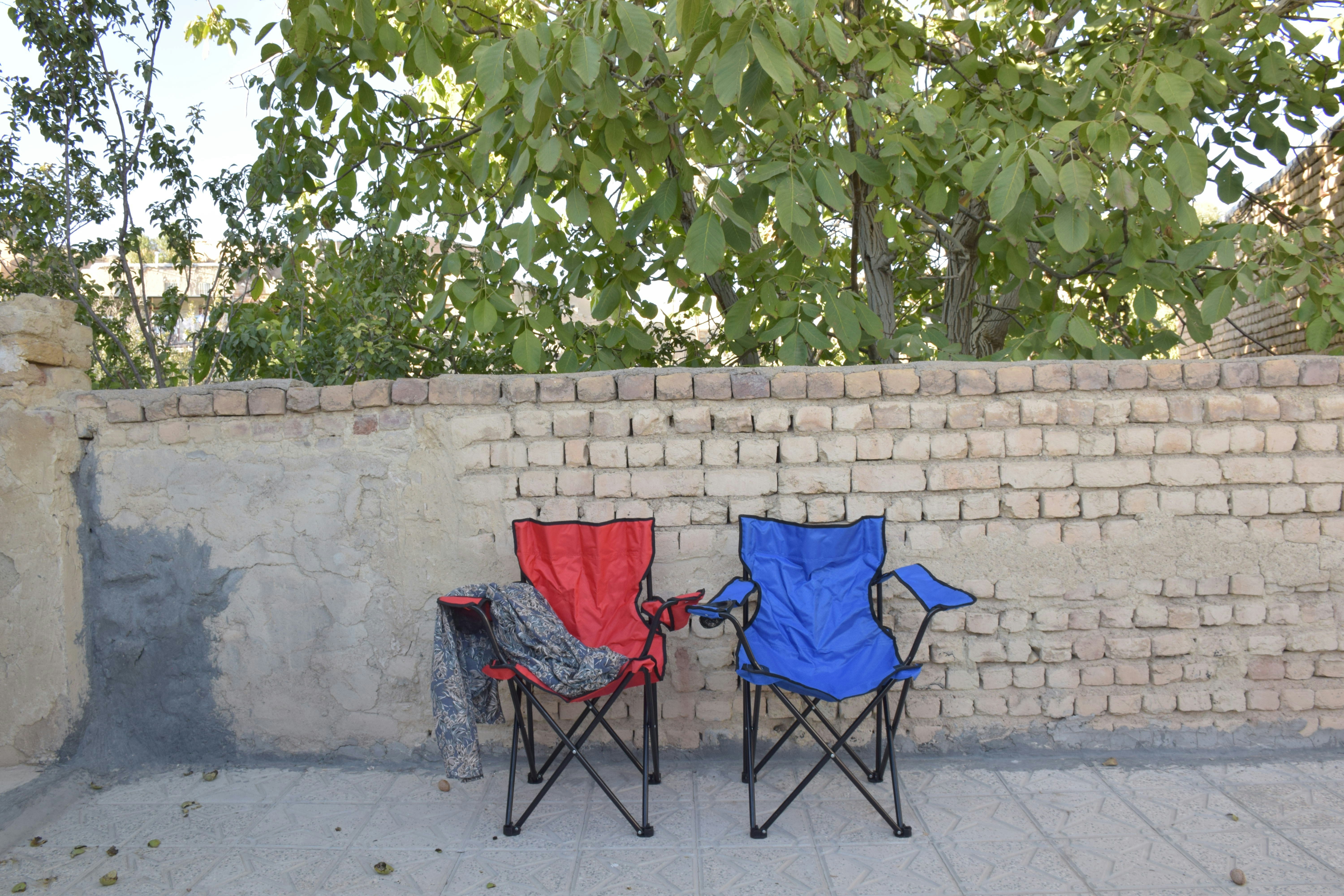 Two camping chairs against a brick wall