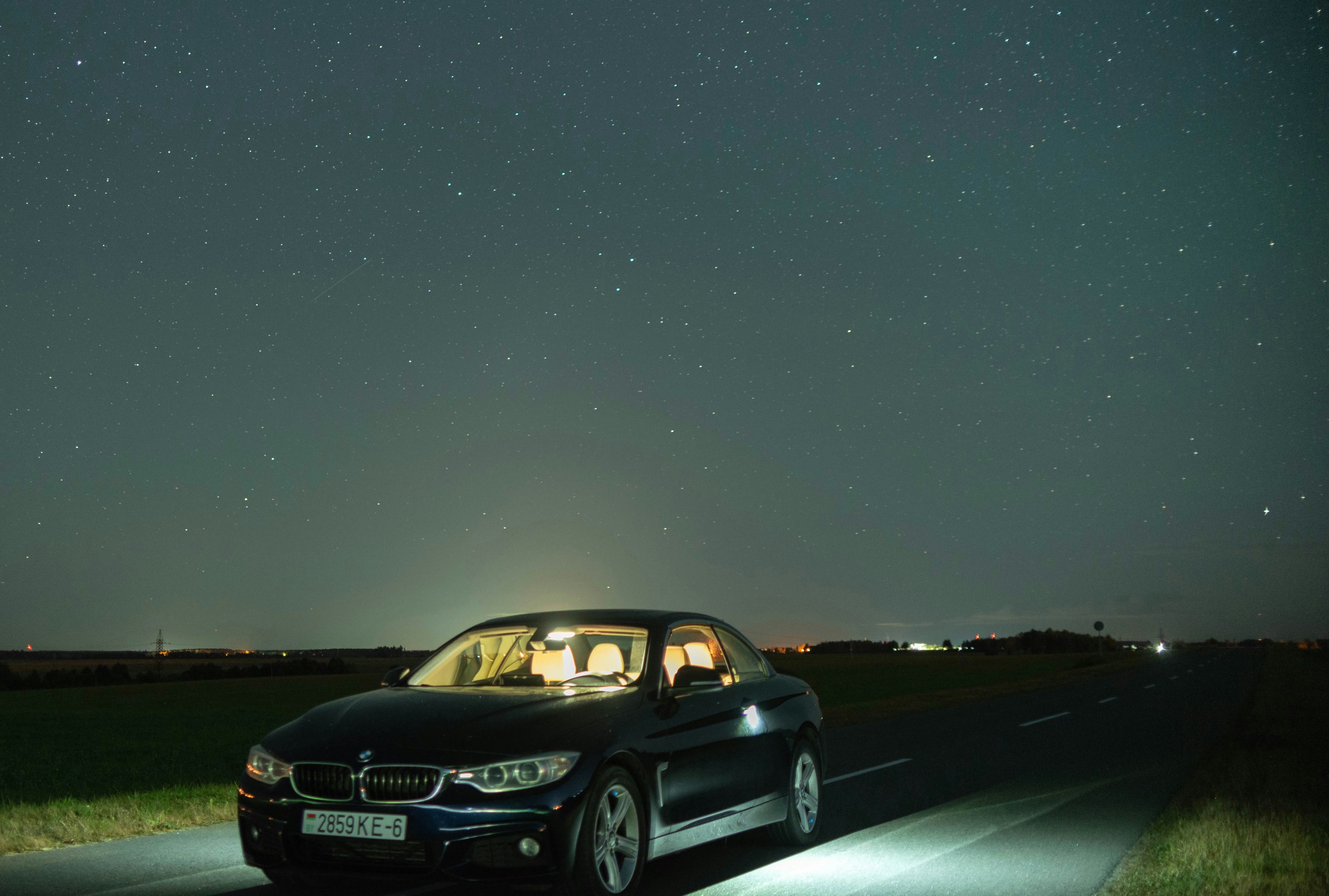 Car parked on road under starry night sky